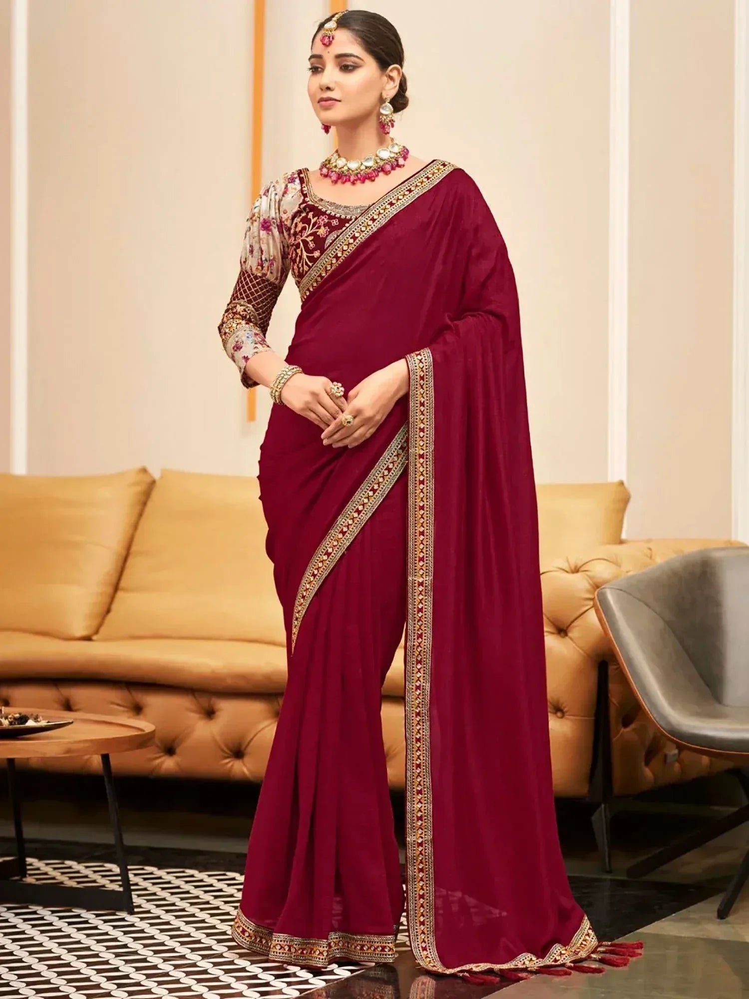Maroon designer saree with gold embroidery, floral blouse, and traditional jewelry for ethnic occasions