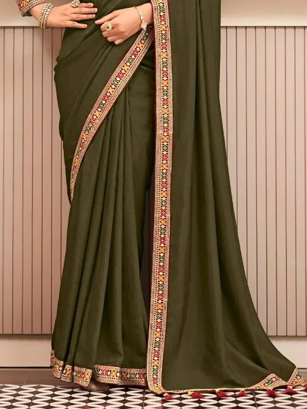 Olive green saree with colorful embroidered border and tassels, perfect for ethnic occasions.