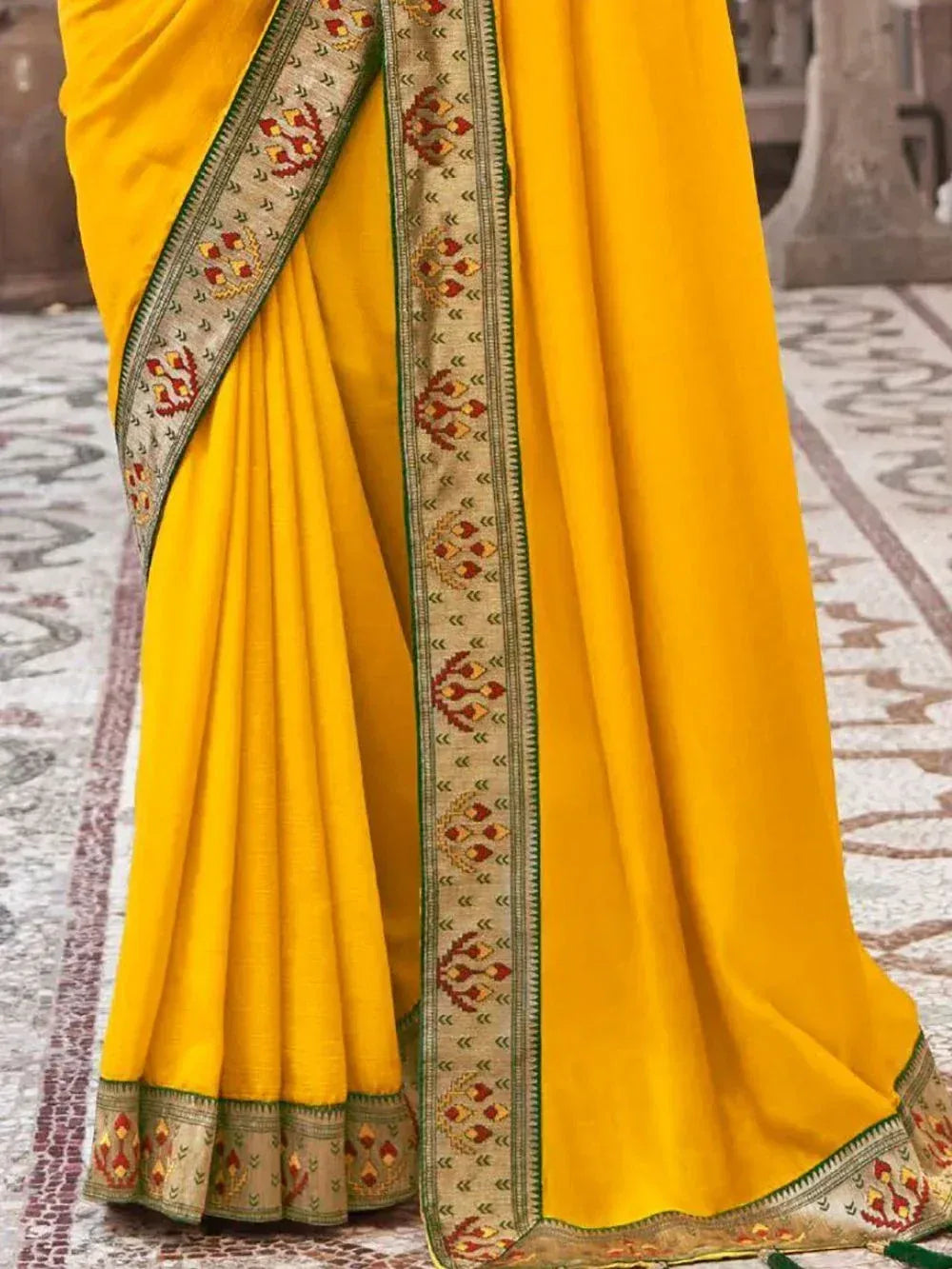 Vibrant yellow ethnic saree with intricate embroidered border, perfect for traditional occasions