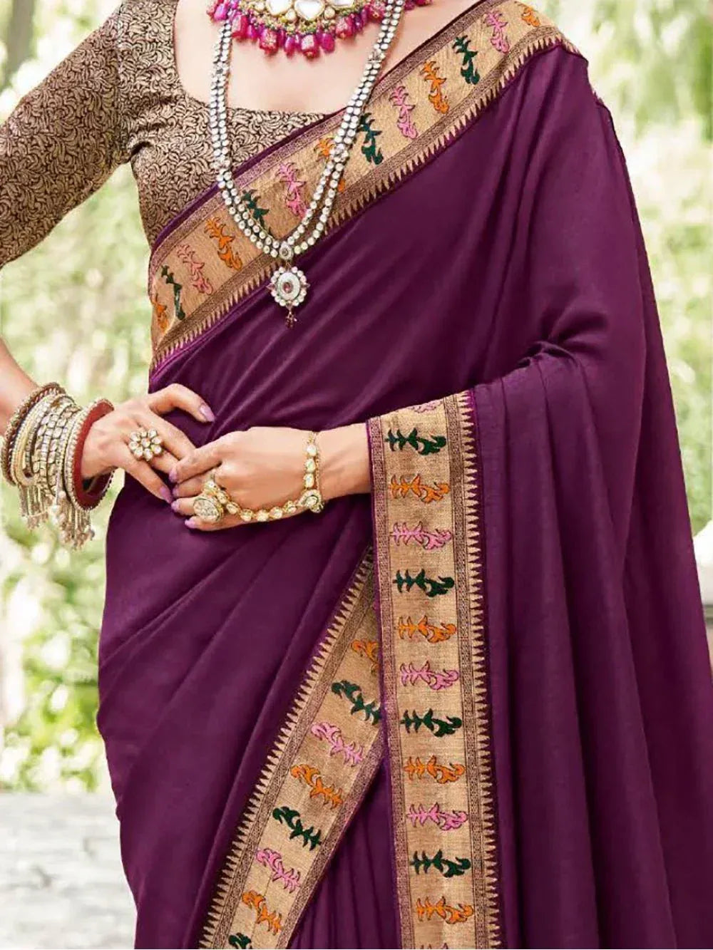 Purple ethnic saree with embroidered border, paired with designer blouse and traditional jewelry