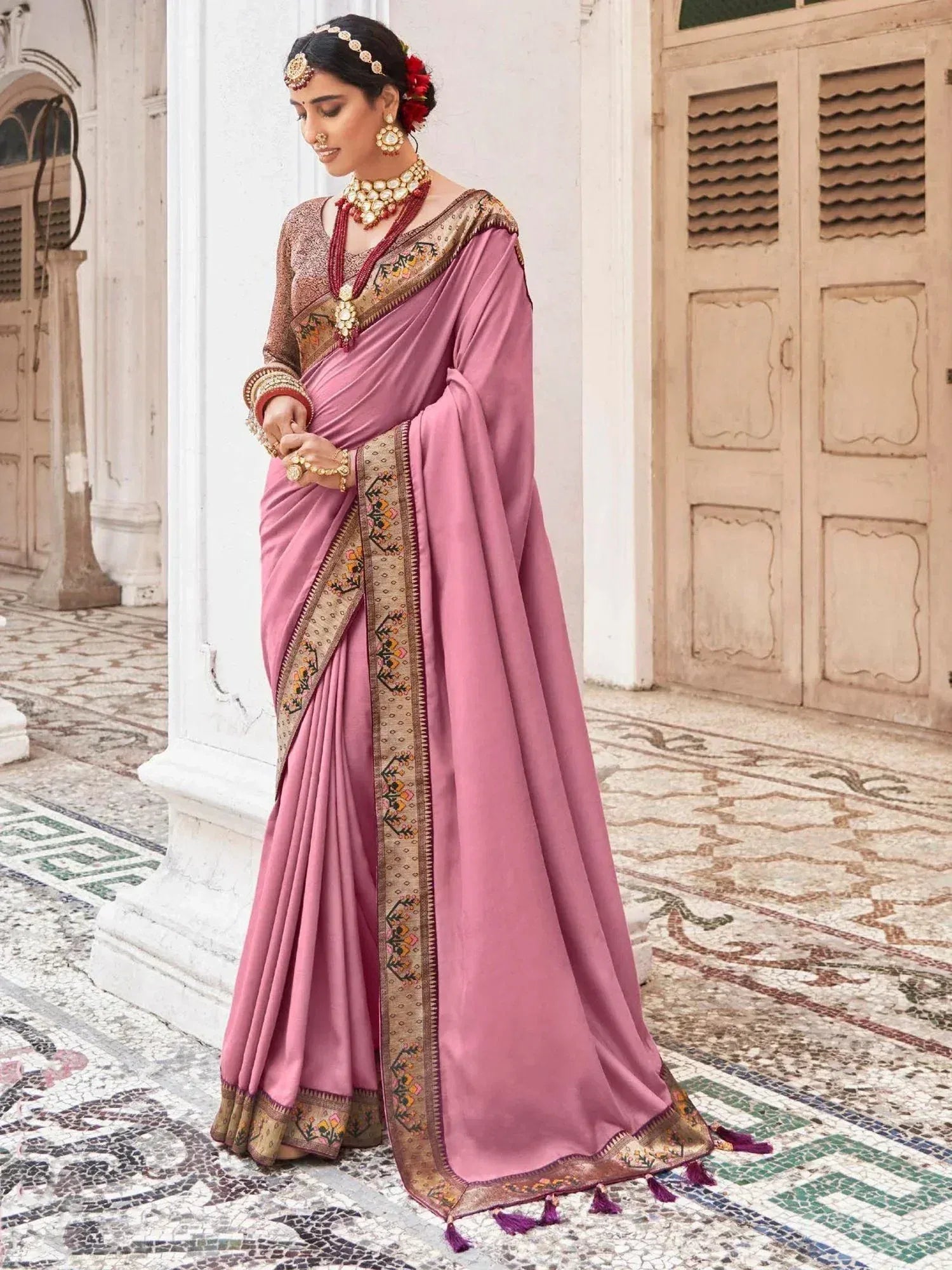 Pink designer saree with embroidered border and traditional jewelry for Indian ethnic wear