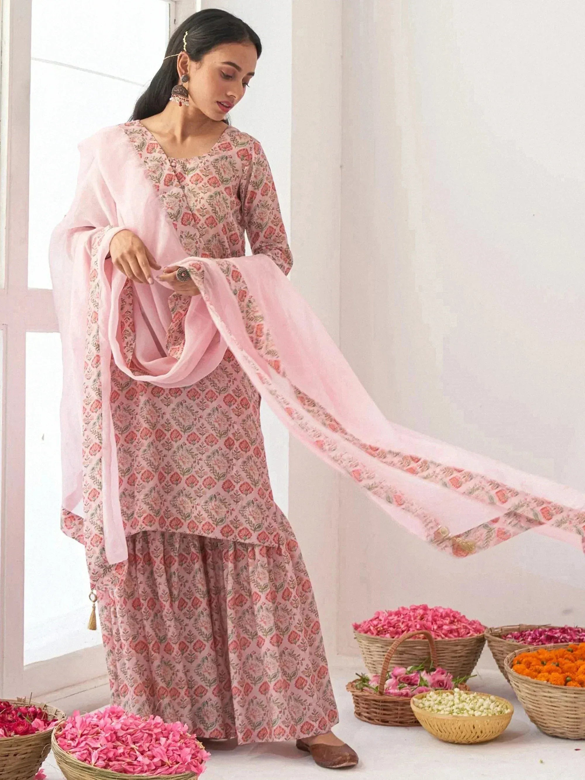 Pink floral printed salwar kameez with matching dupatta, styled with flowers for ethnic wear