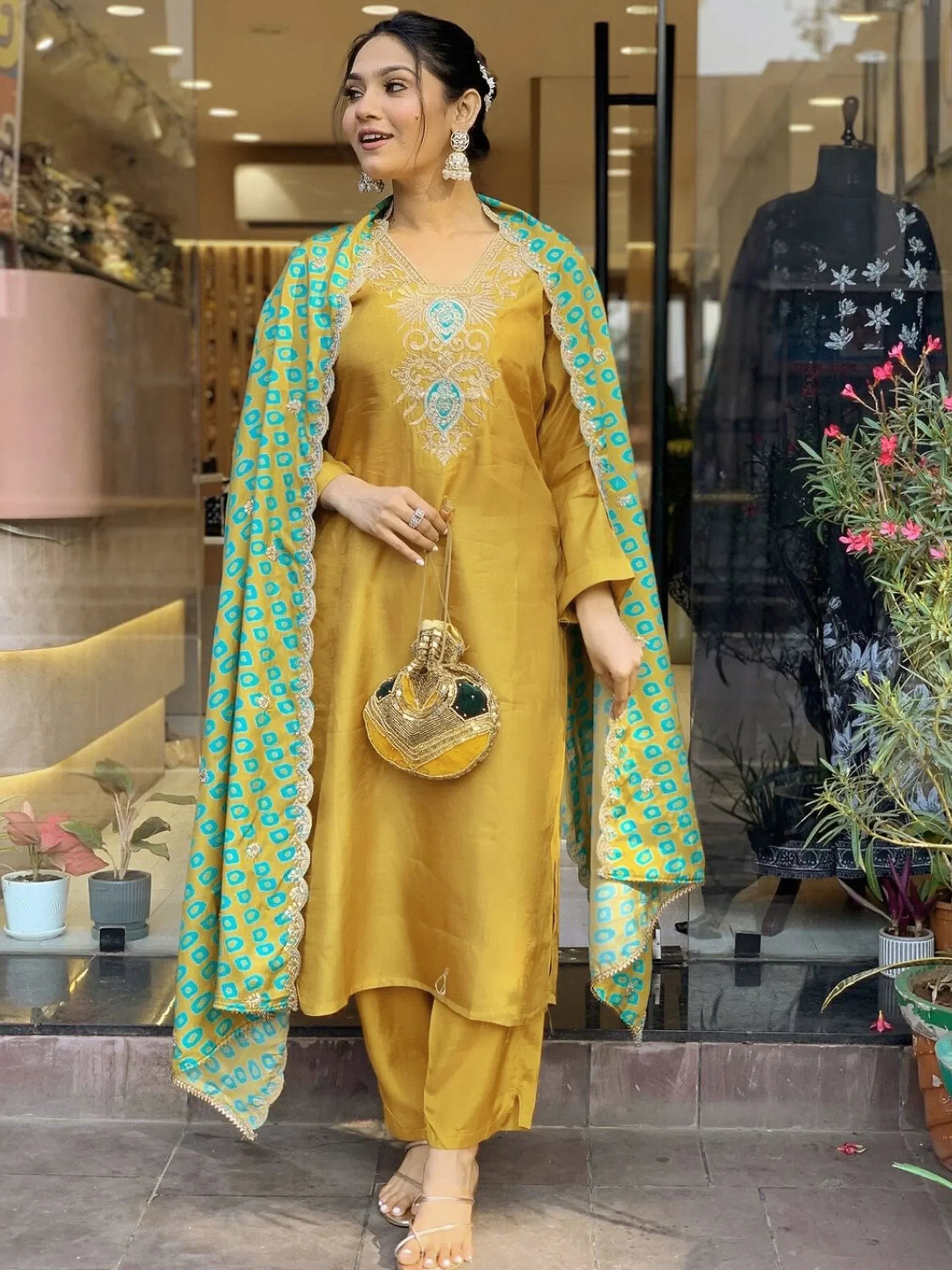 Woman in mustard yellow salwar kameez with blue embroidered dupatta, ethnic Indian outfit