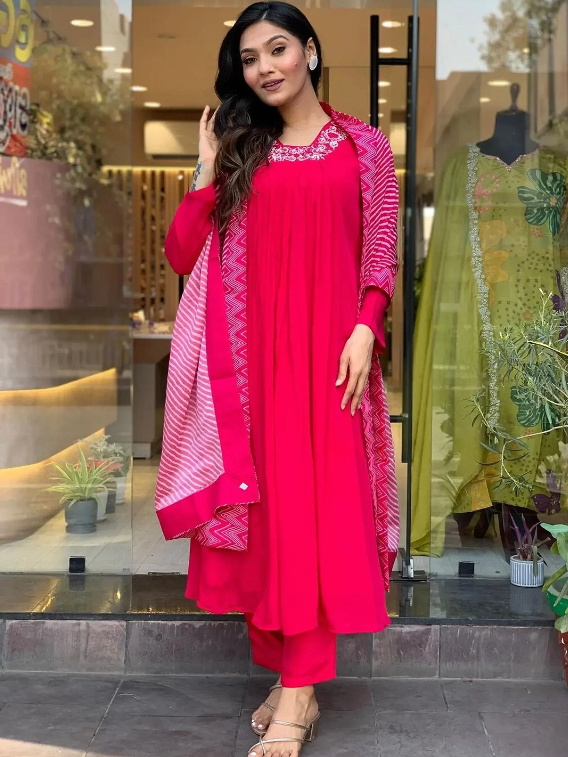 Vibrant pink ethnic salwar kameez with embroidered neckline and patterned dupatta, perfect for Indian occasions.