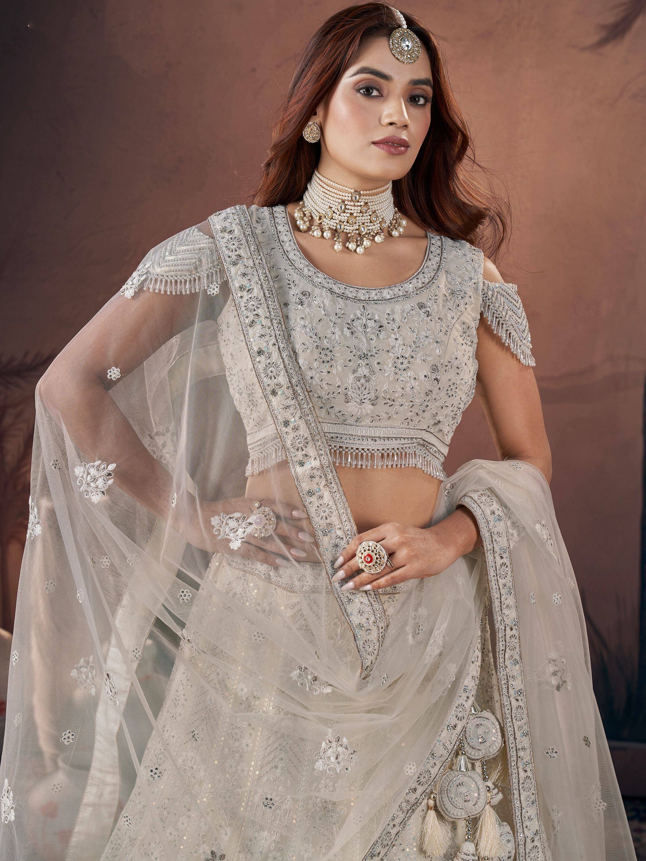 Elegant ivory lehenga choli with intricate embroidery and pearl jewelry for Indian weddings