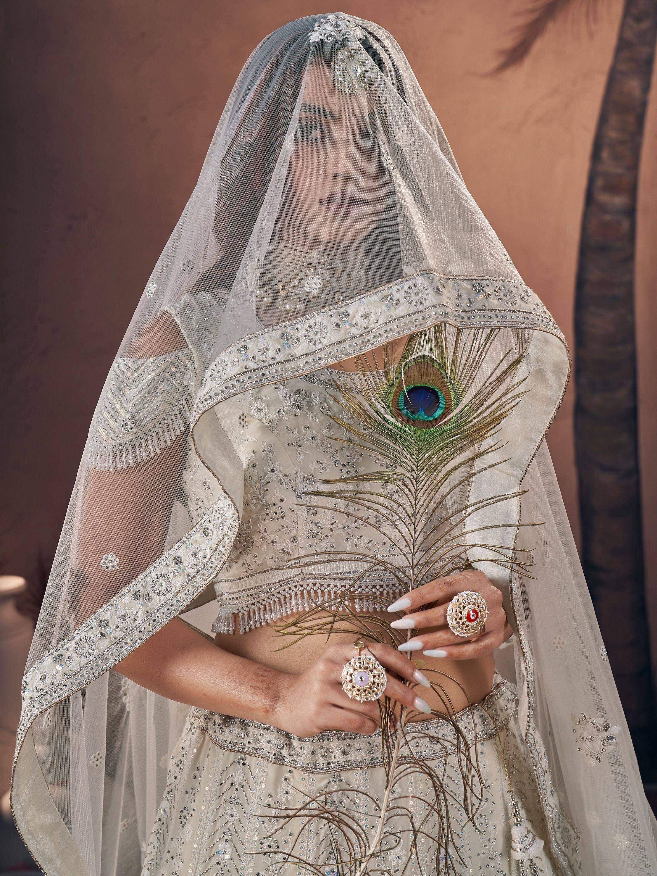 Elegant Indian bridal lehenga choli with peacock feather embroidery and sheer dupatta, perfect for wedding ceremonies.
