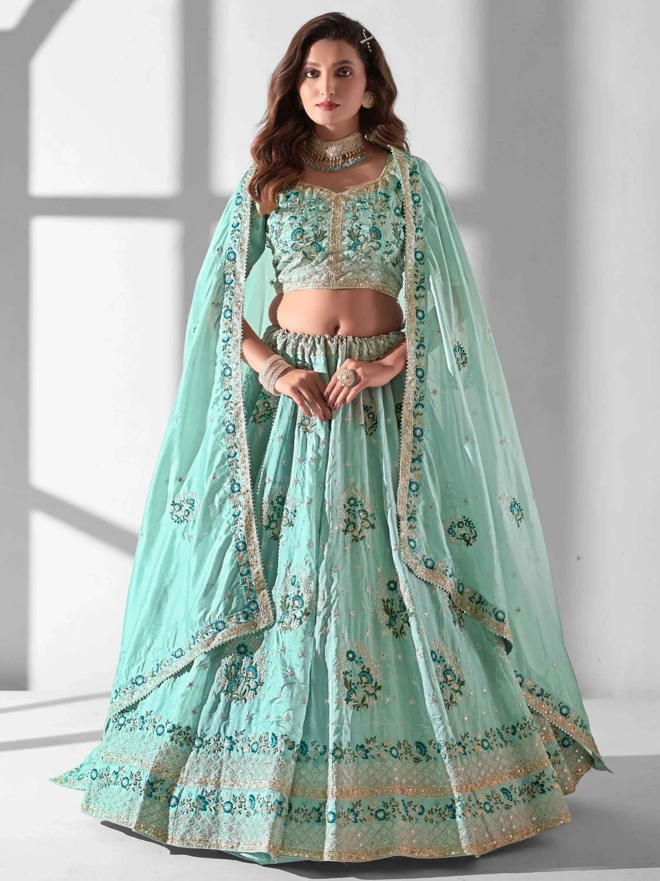Mint green embroidered lehenga choli with floral motifs and gold detailing, perfect for Indian ethnic wear