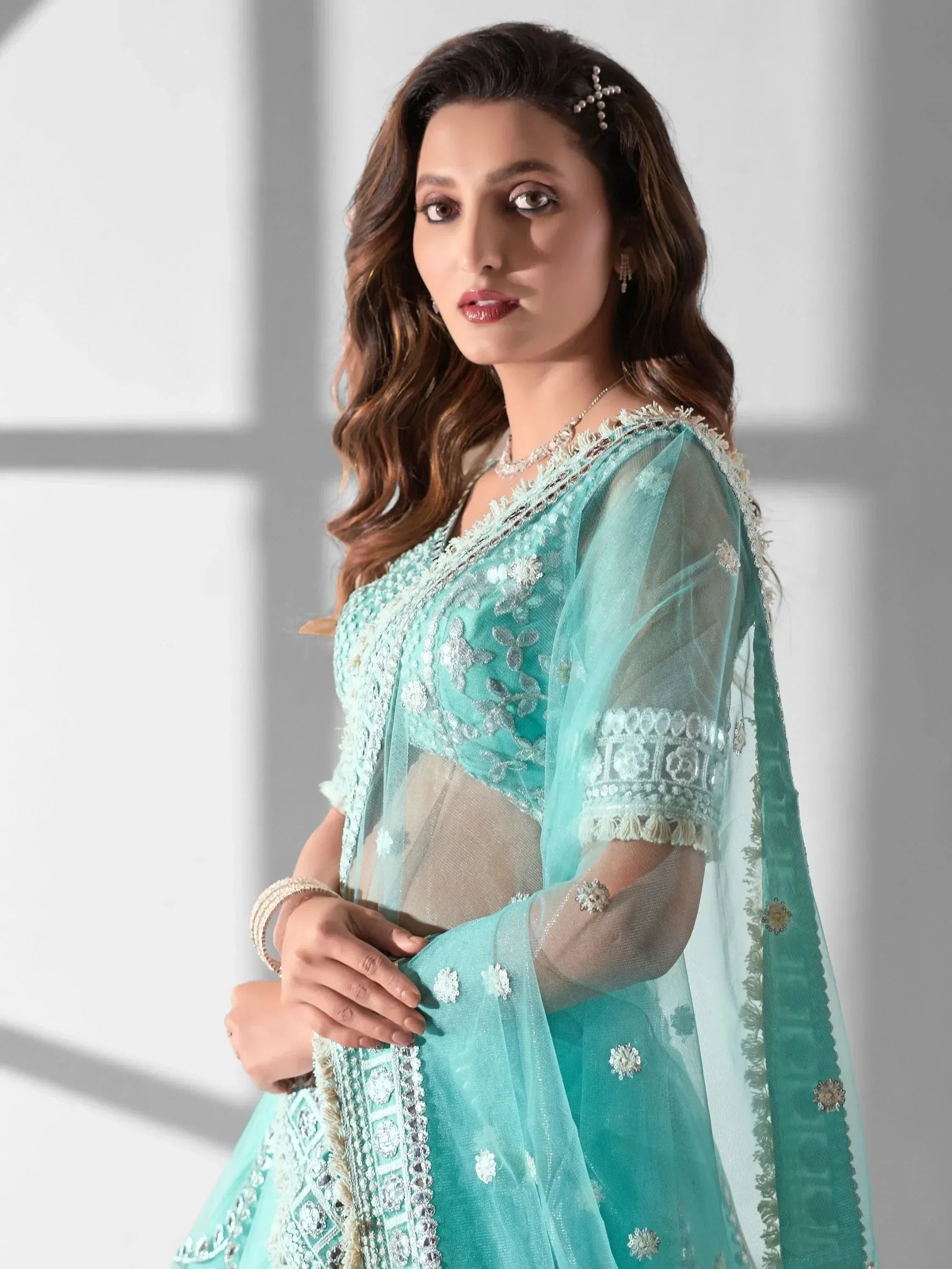 Elegant mint green embroidered lehenga choli with sheer dupatta, perfect for Indian ethnic occasions.
