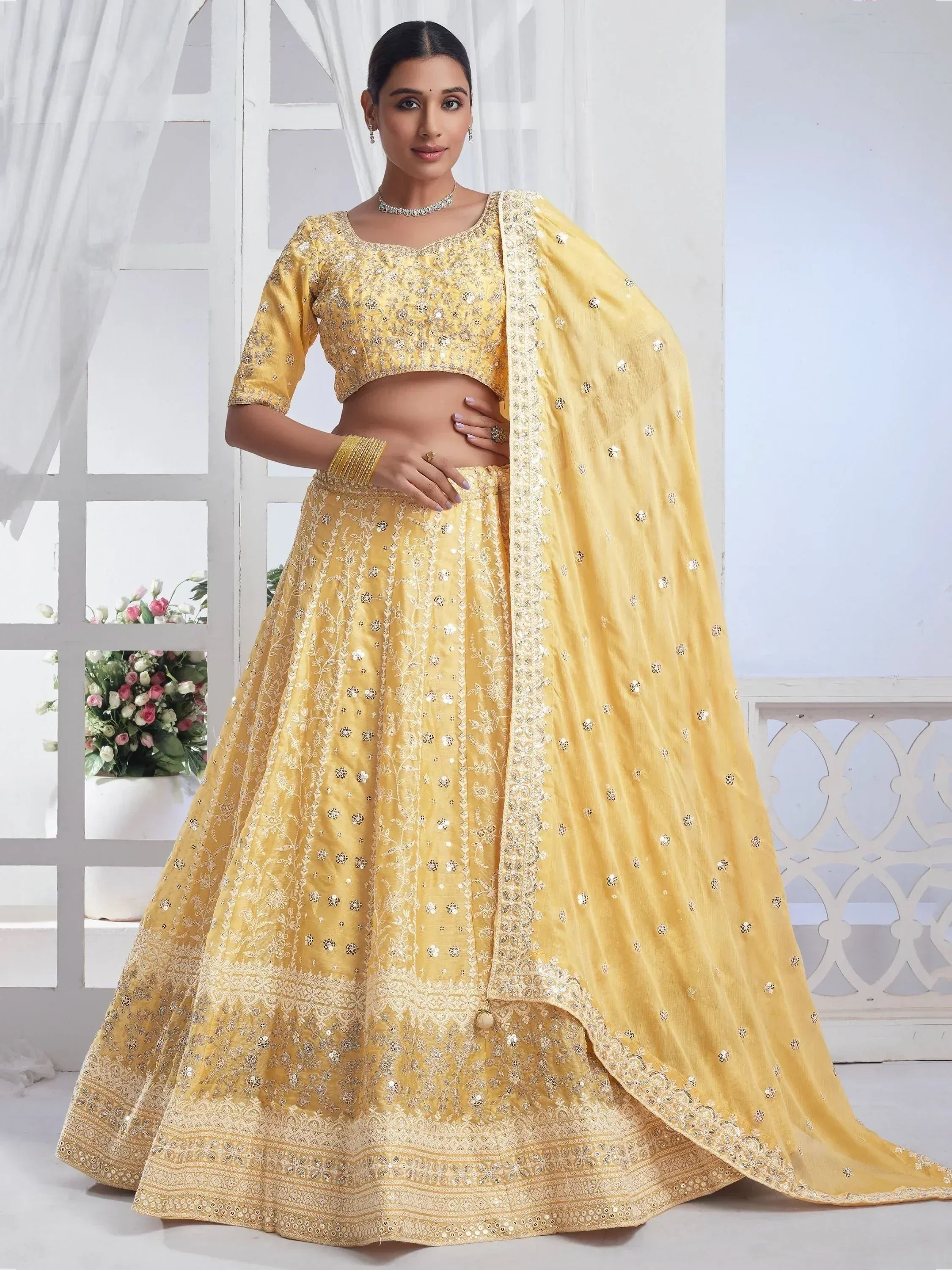 Yellow embroidered lehenga choli with mirror work and dupatta, perfect for Indian ethnic occasions