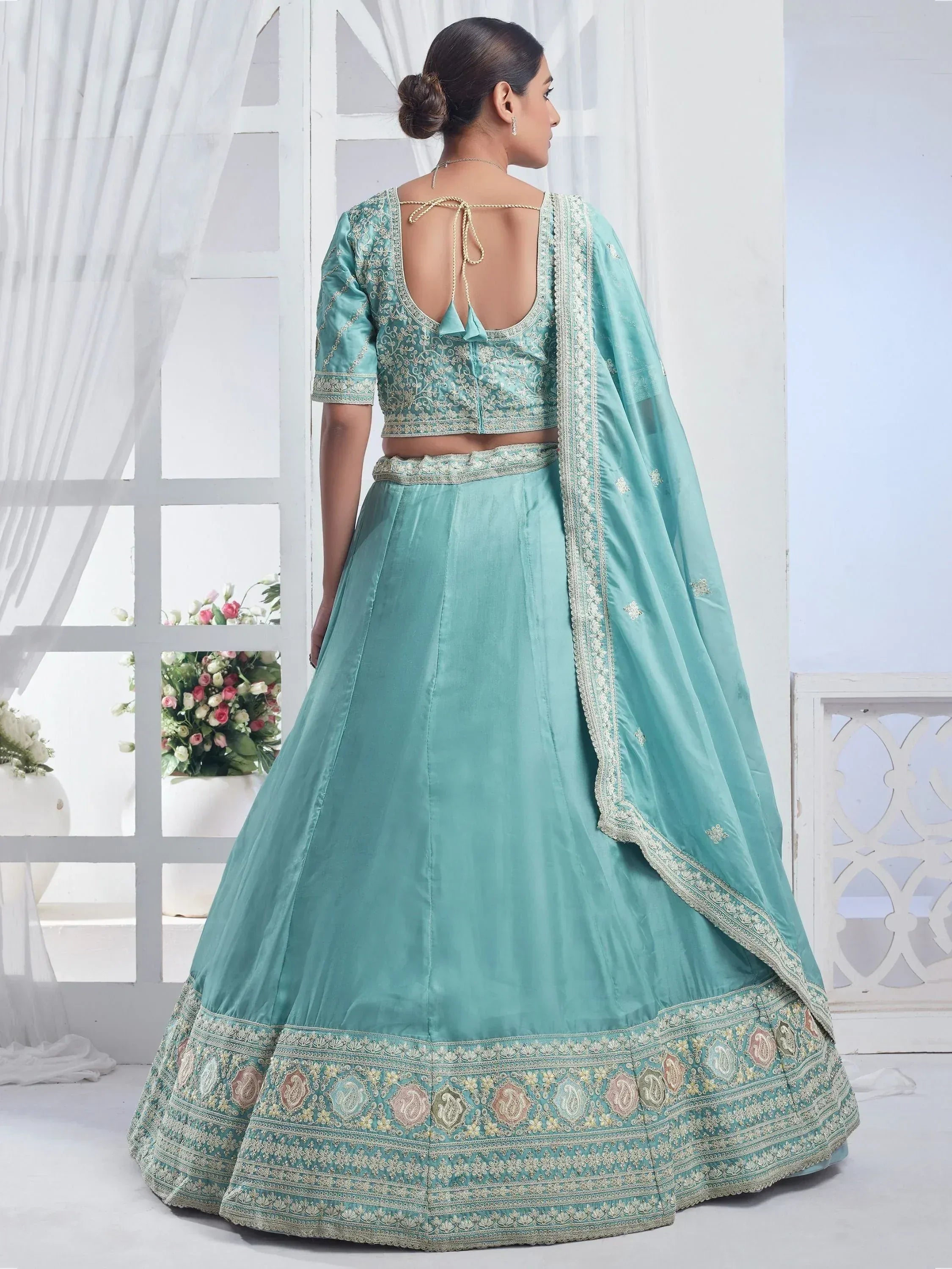 Mint green designer lehenga choli with intricate embroidery and back tie blouse, perfect for weddings and parties.