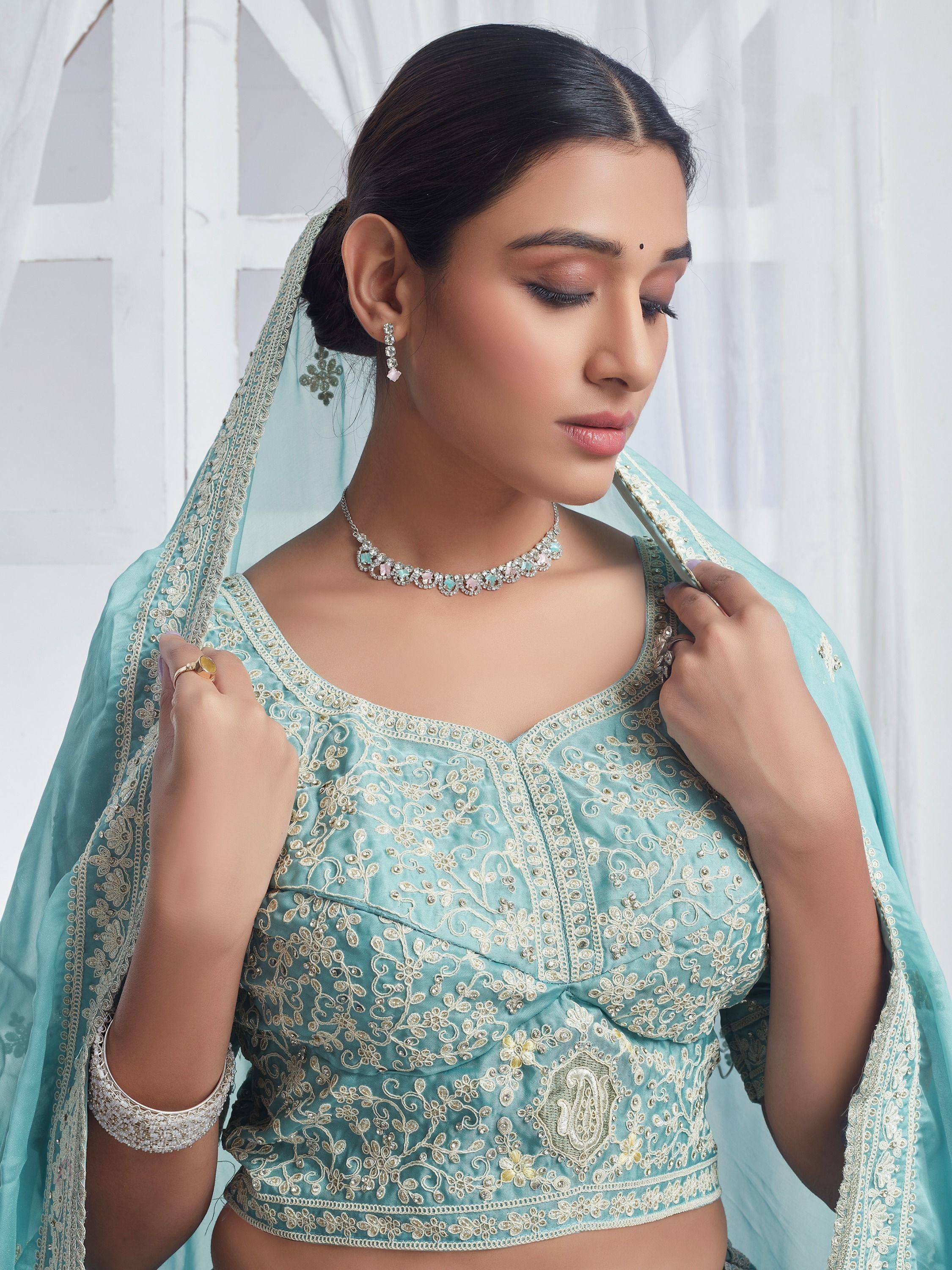 Elegant mint green embroidered lehenga choli with matching dupatta and jewelry, perfect for Indian ethnic occasions.