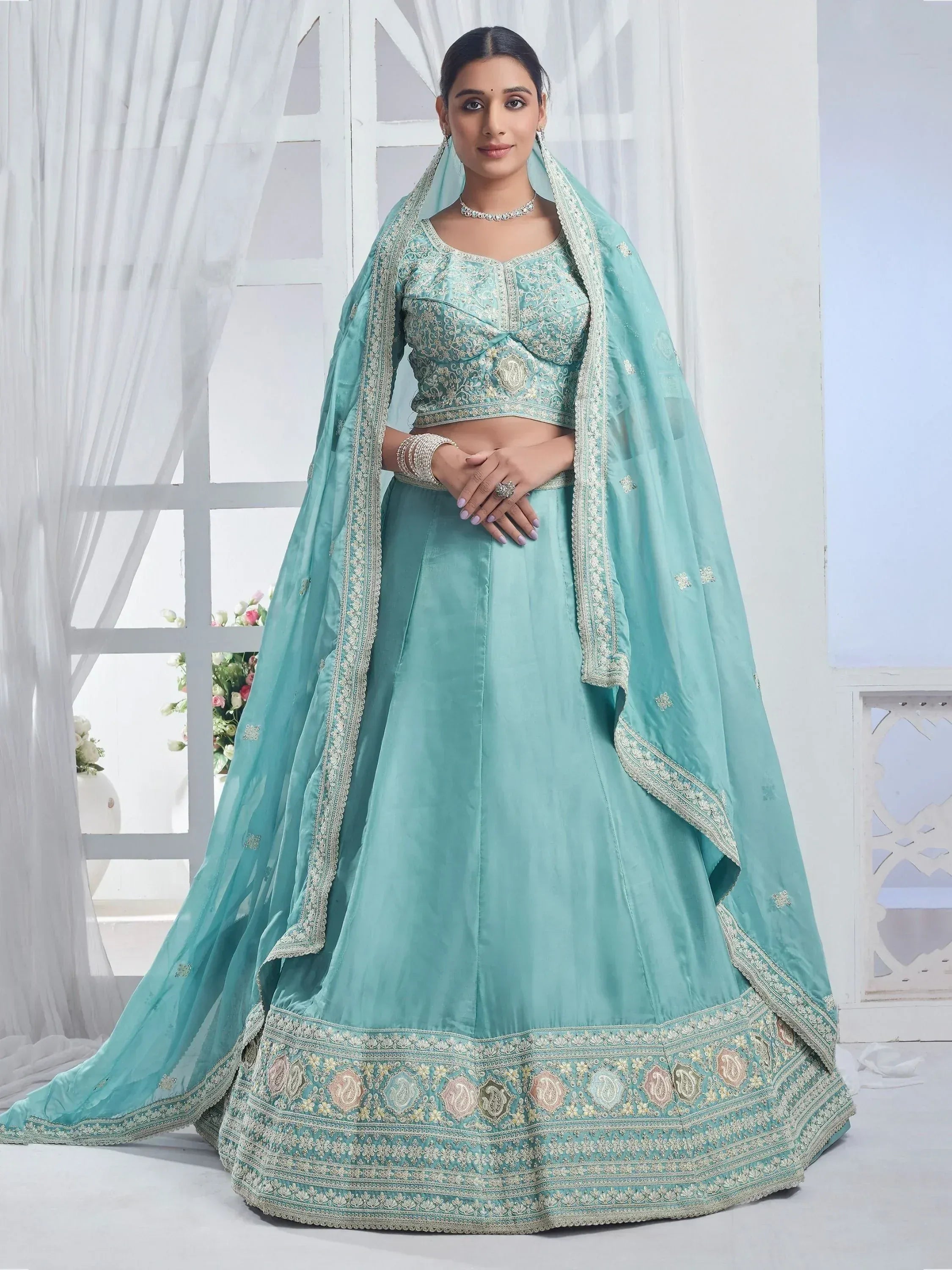 Mint green designer lehenga choli with heavy embroidery and dupatta, perfect for Indian weddings and festive occasions.