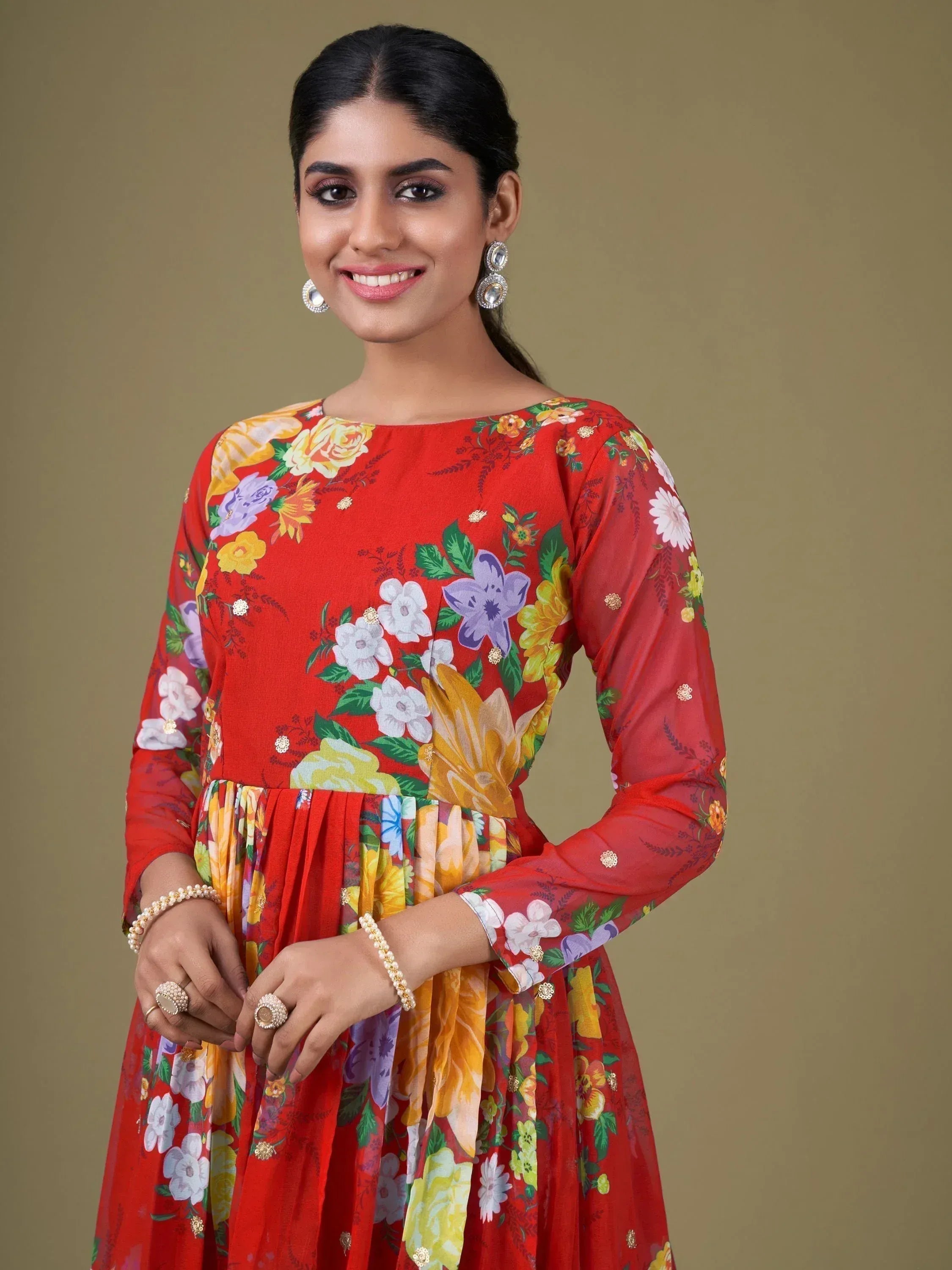 Woman in red floral ethnic gown with long sleeves, perfect for Indian occasions and festive wear.