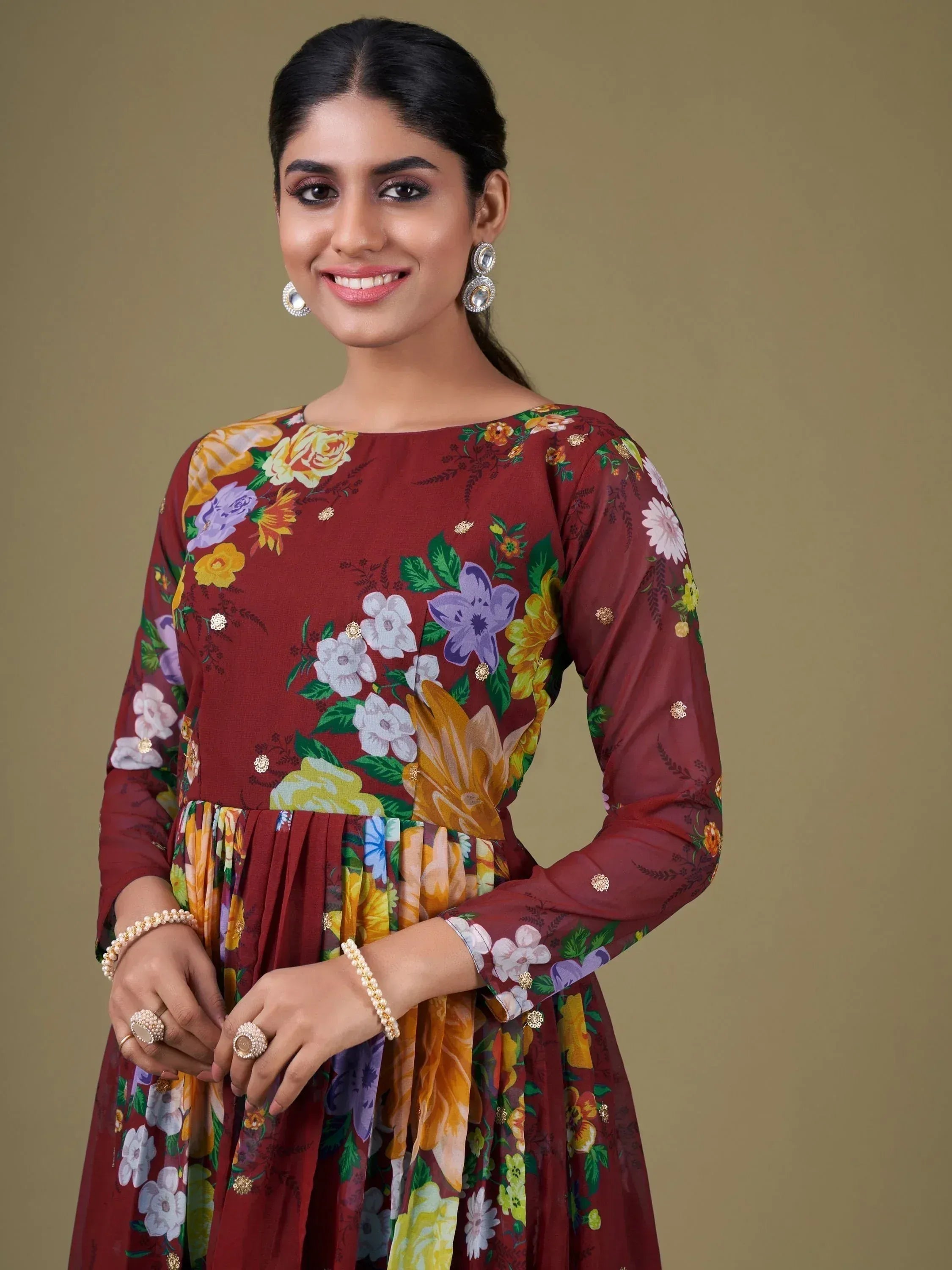 Woman in maroon floral ethnic gown with gold embellishments, perfect for Indian occasions