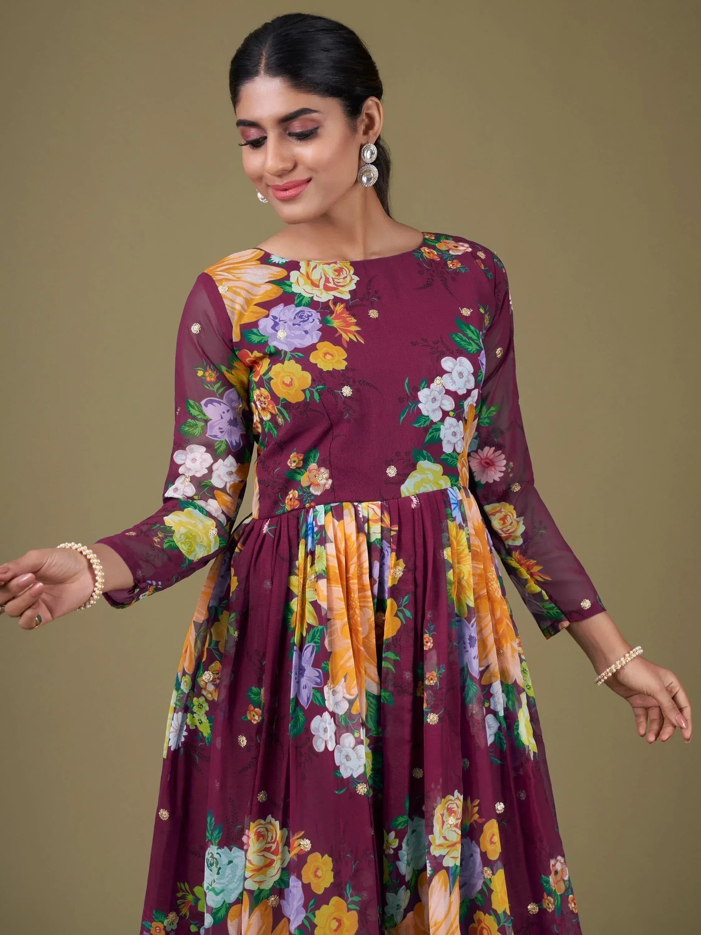 Maroon floral print ethnic gown with sheer sleeves and gold embellishments, perfect for Indian occasions