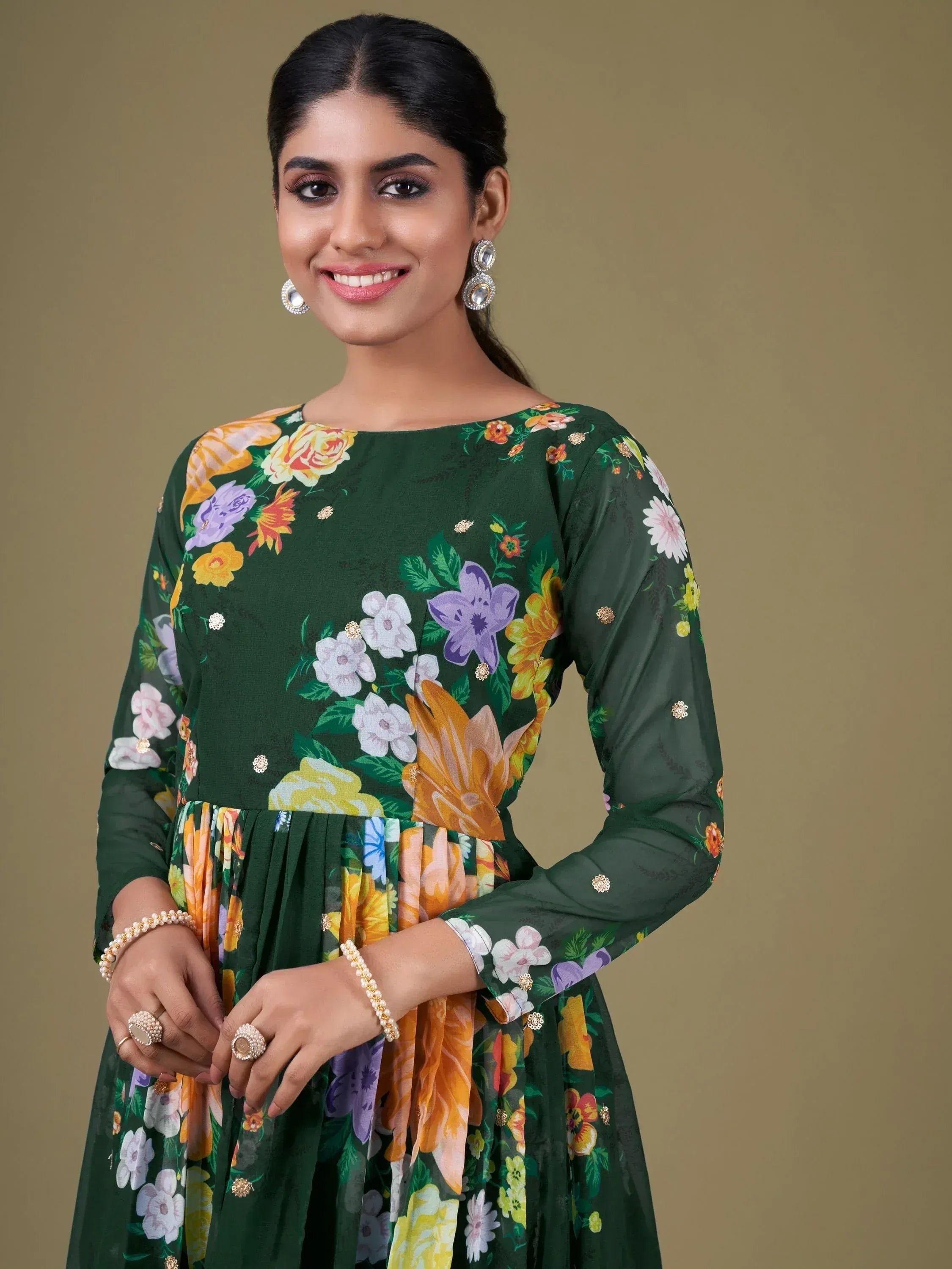 Woman in green floral ethnic gown with gold embellishments, perfect for Indian occasions