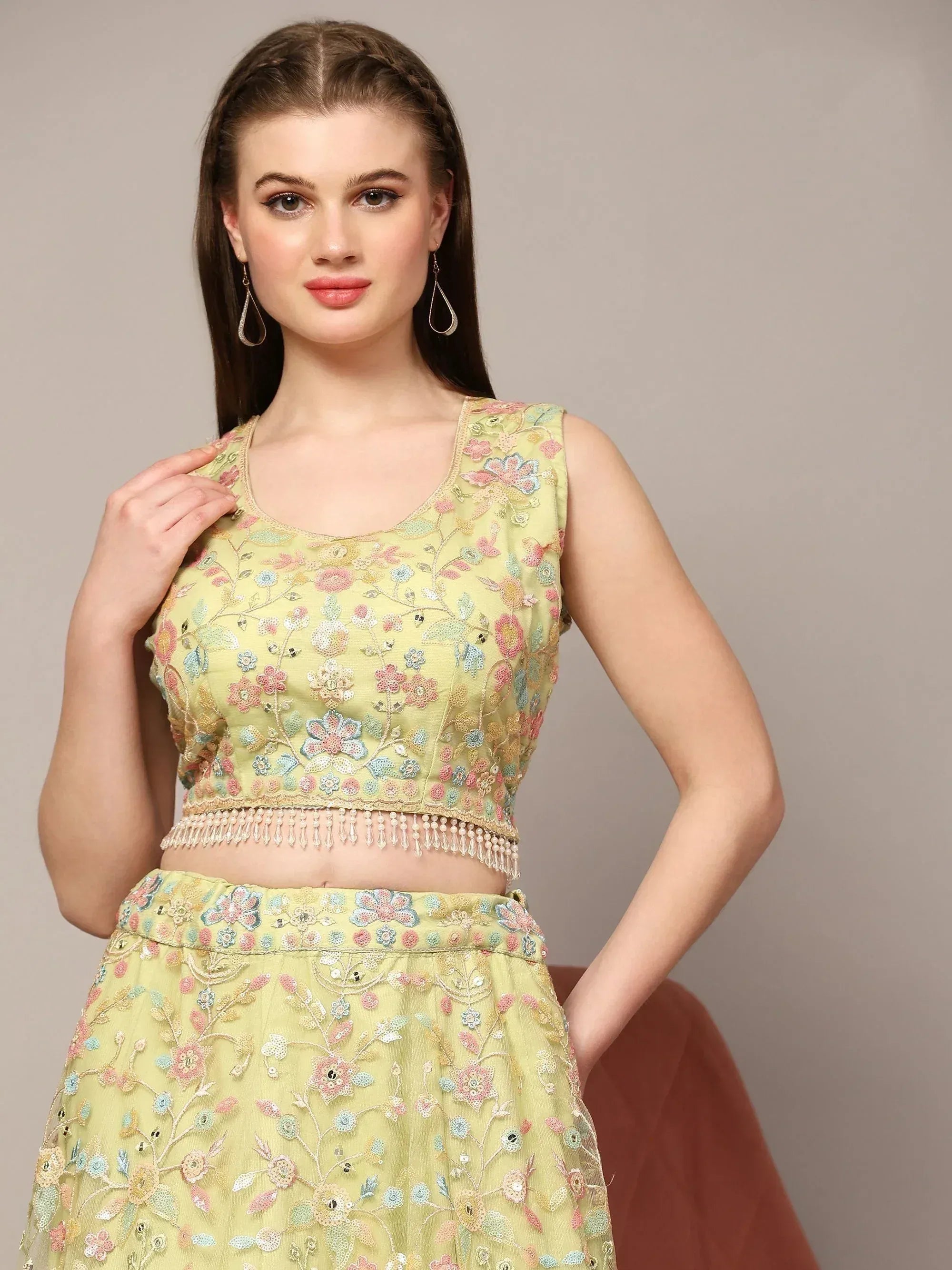 Light green embroidered lehenga choli with floral motifs and pearl tassels, perfect for Indian ethnic wear
