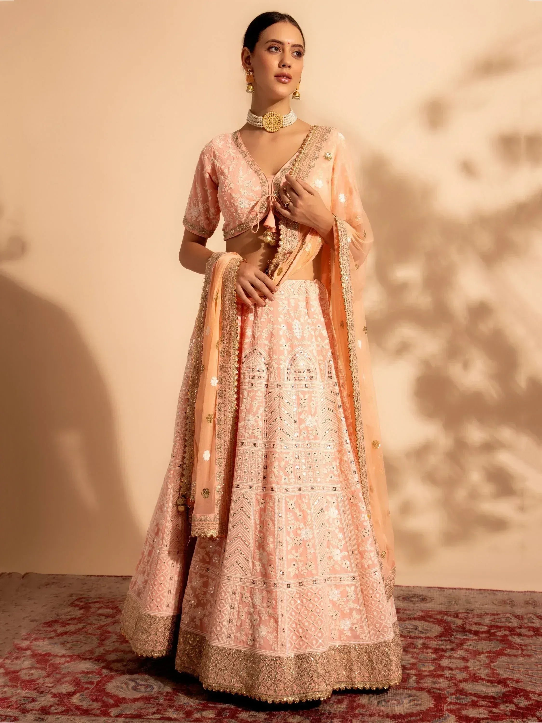Pink embroidered lehenga choli with gold detailing, perfect for Indian weddings and festive occasions.