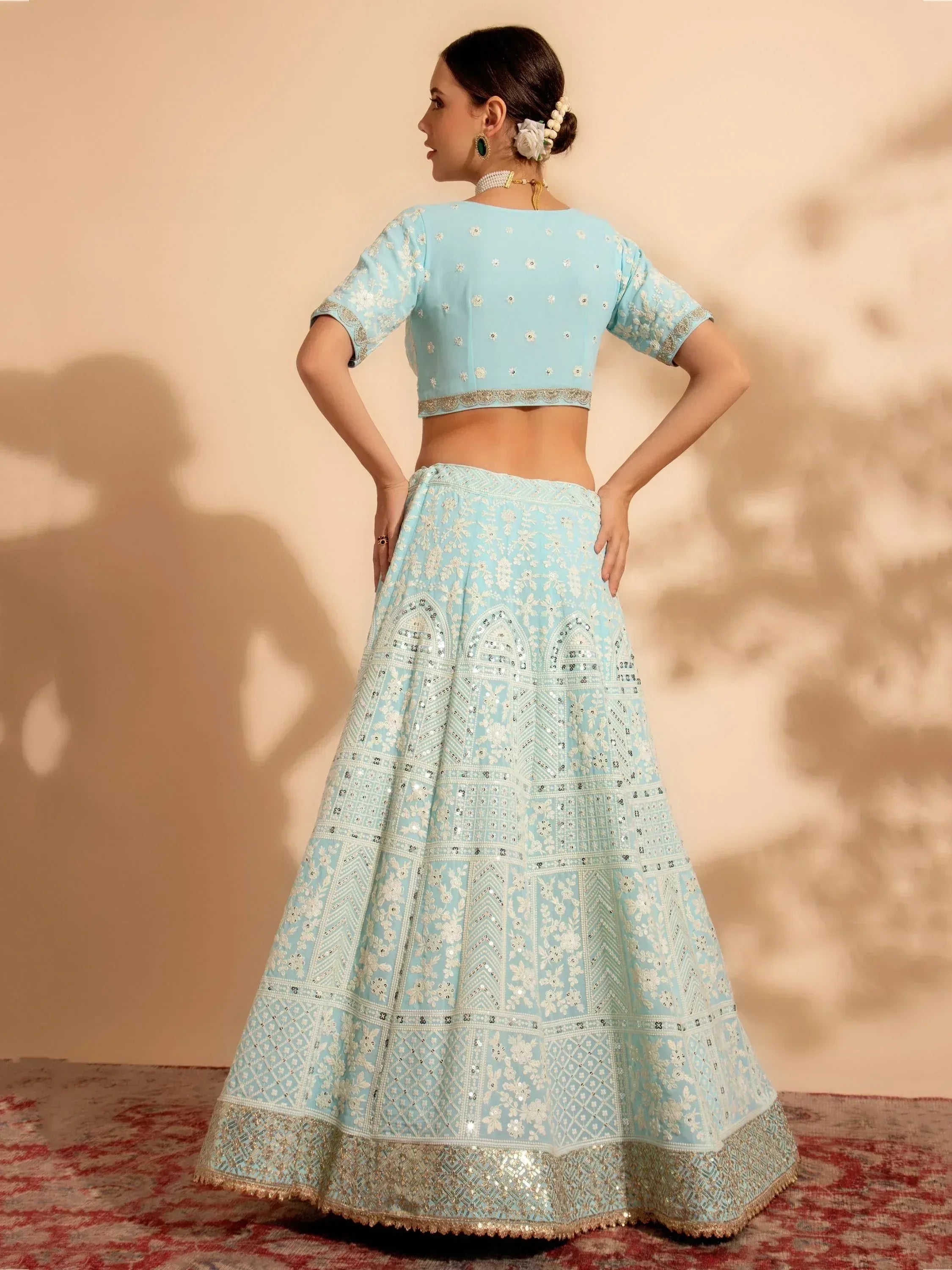 Light blue embroidered lehenga choli with floral motifs and sequin detailing, perfect for Indian ethnic occasions.