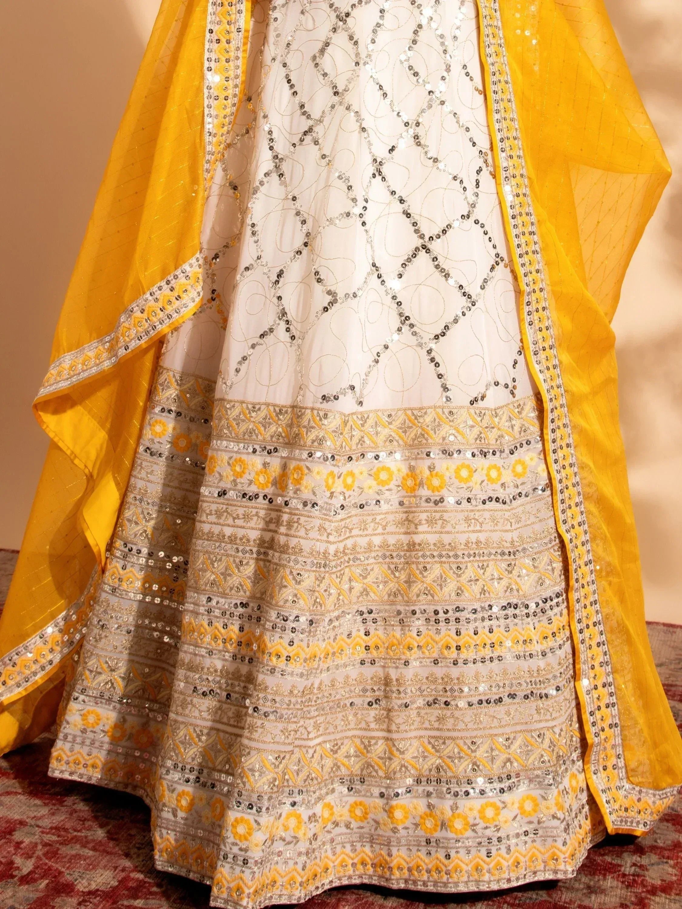 White and yellow embroidered lehenga choli with sequin work and floral border, perfect for Indian ethnic wear.