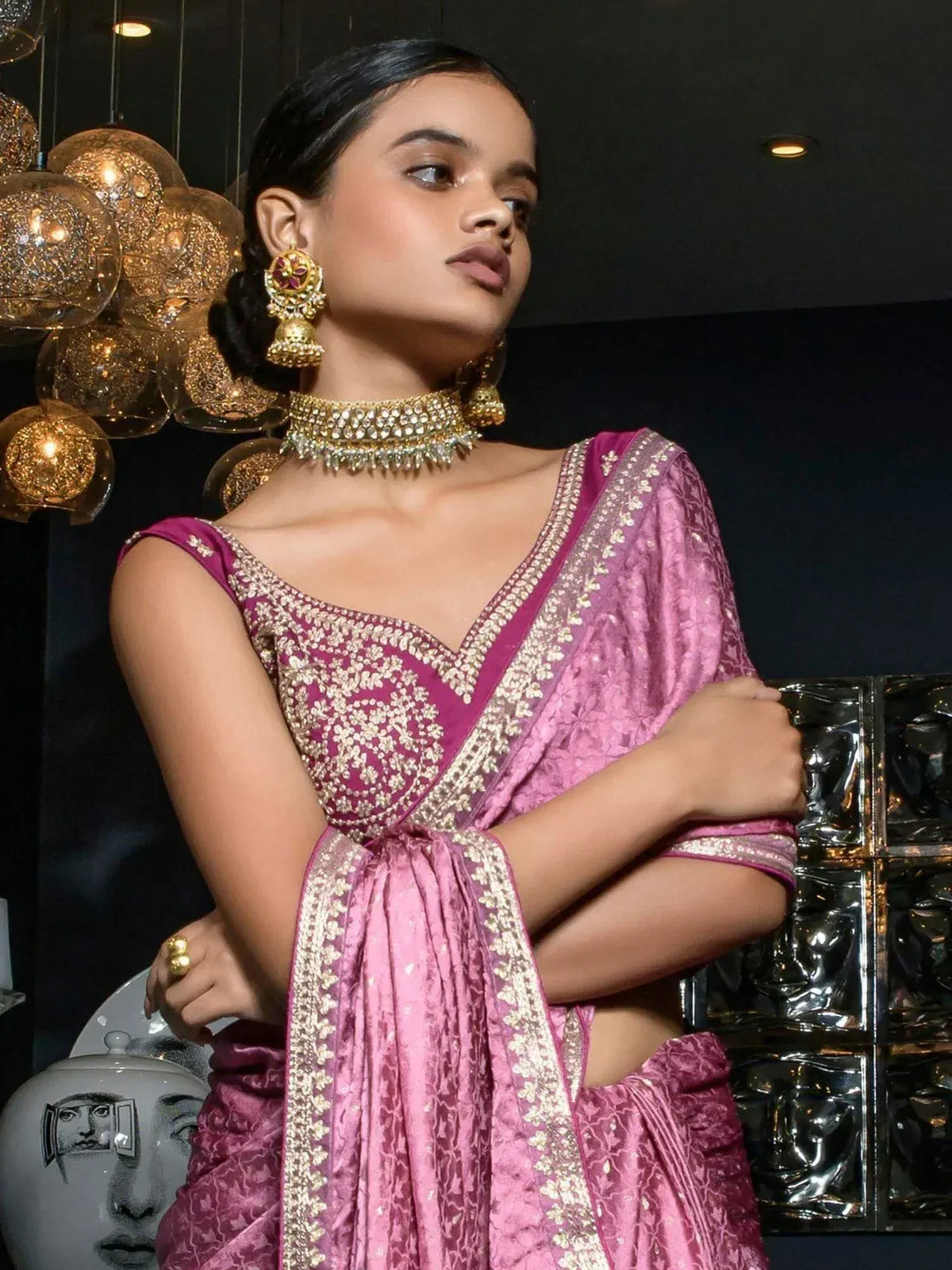 Elegant pink designer saree with gold embroidery, paired with traditional Indian jewelry for festive occasions