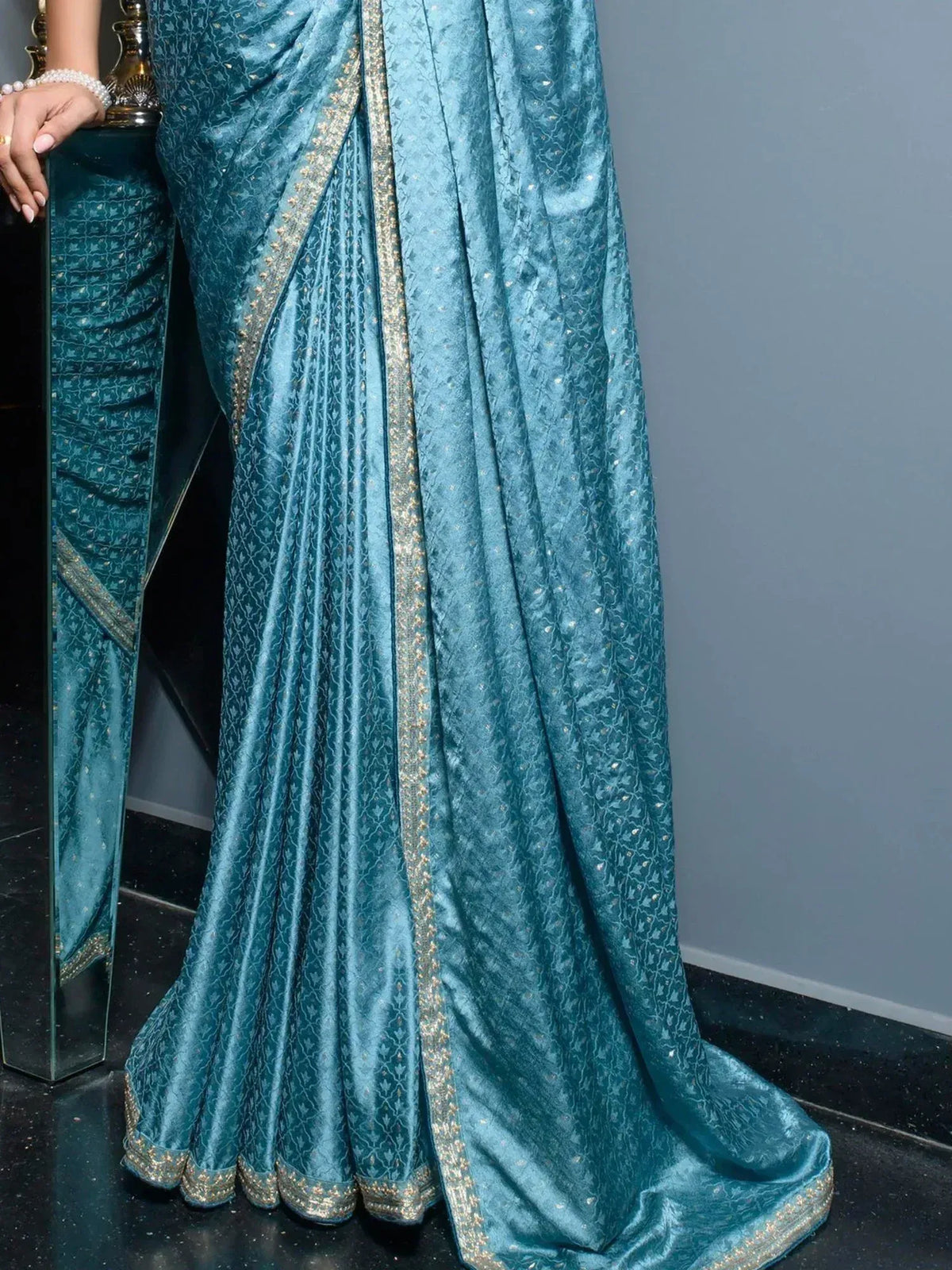 Teal blue designer saree with gold border and intricate patterns, elegant ethnic wear for women