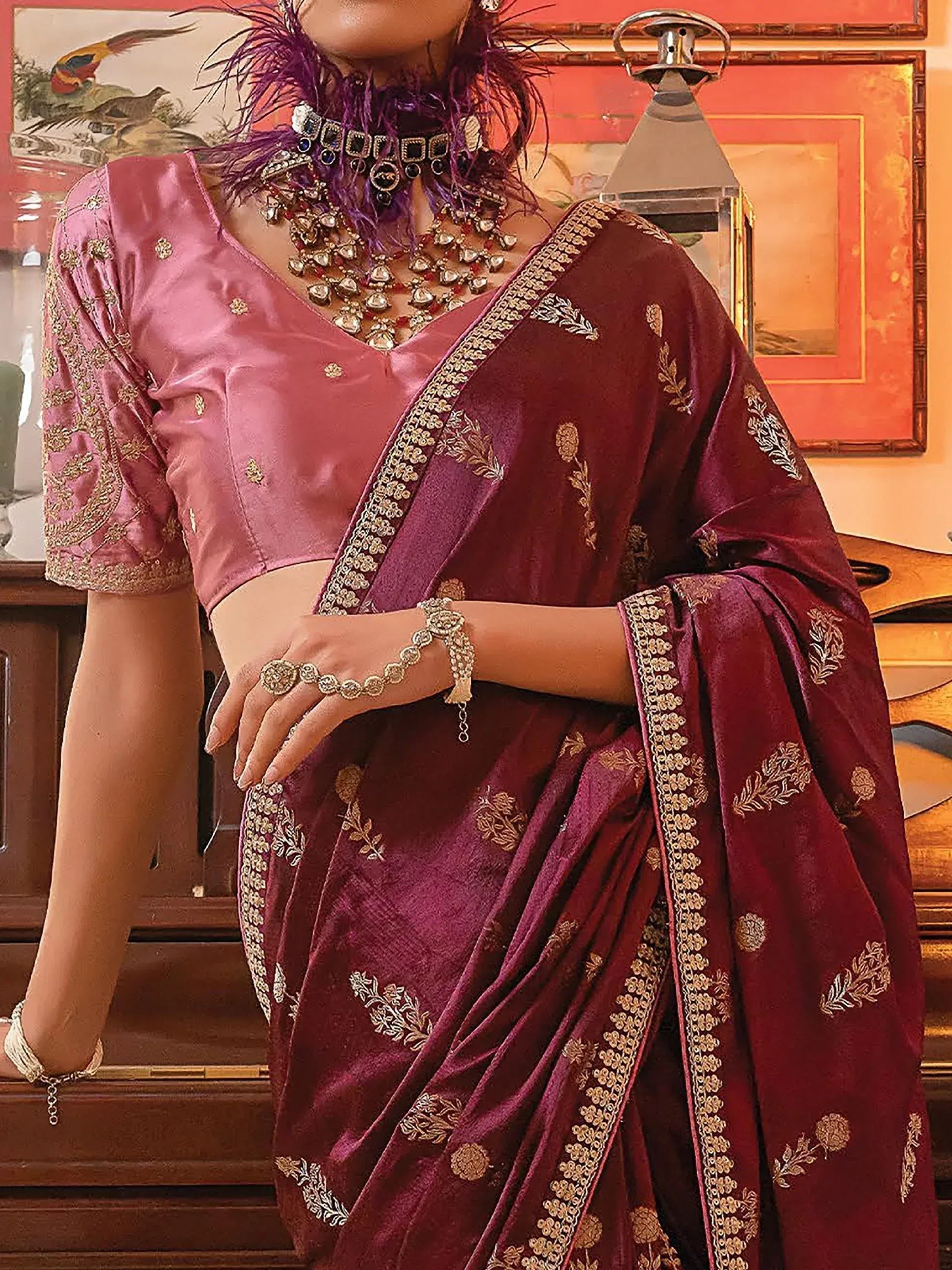Elegant maroon velvet saree with gold embroidery, paired with pink blouse and traditional jewelry for Indian ethnic wear