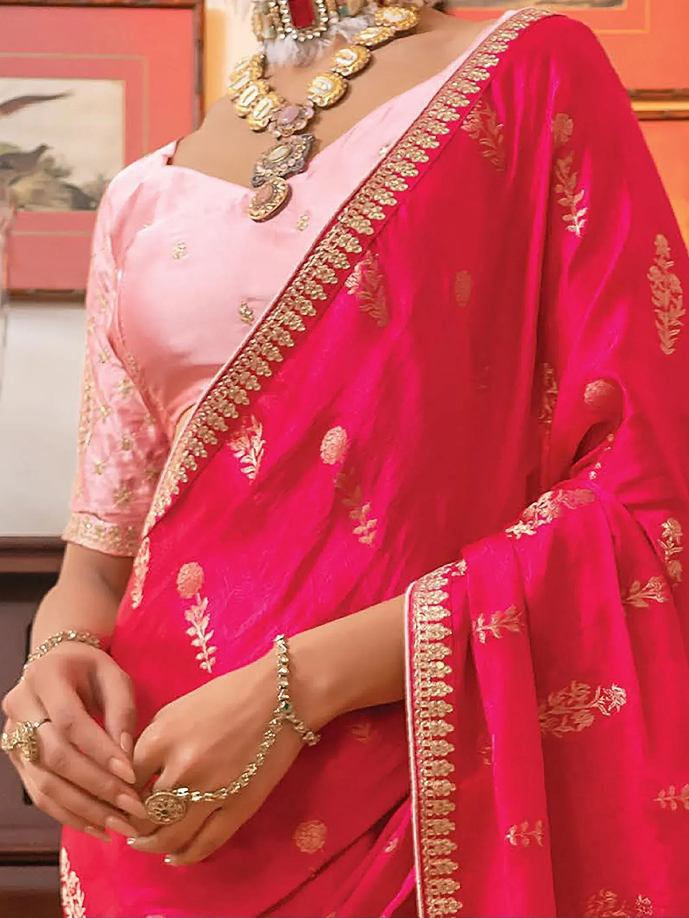 Pink and red embroidered saree with gold border, traditional Indian ethnic wear, paired with ornate jewelry
