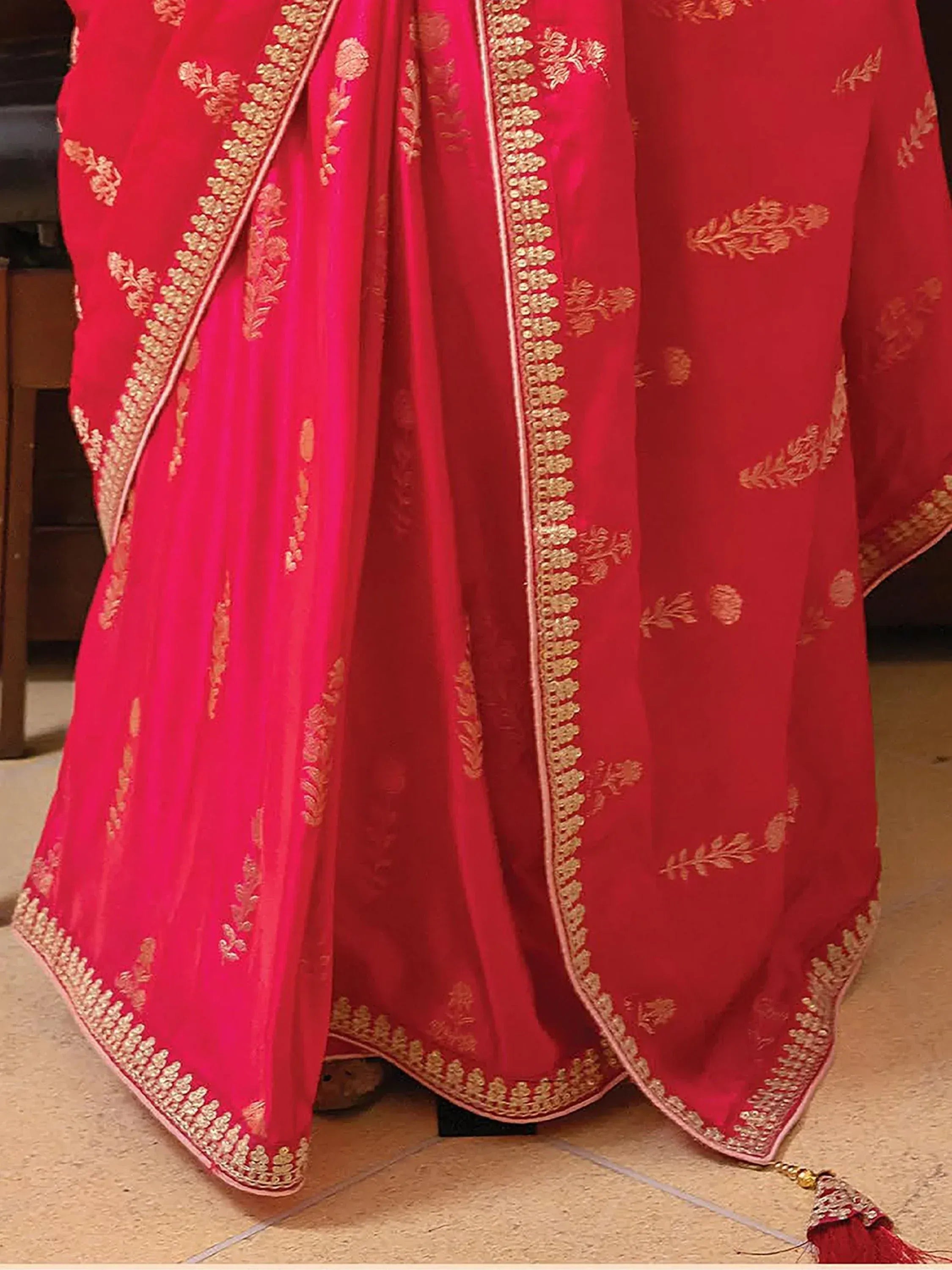 Red and pink ethnic lehenga with gold floral embroidery and border detailing