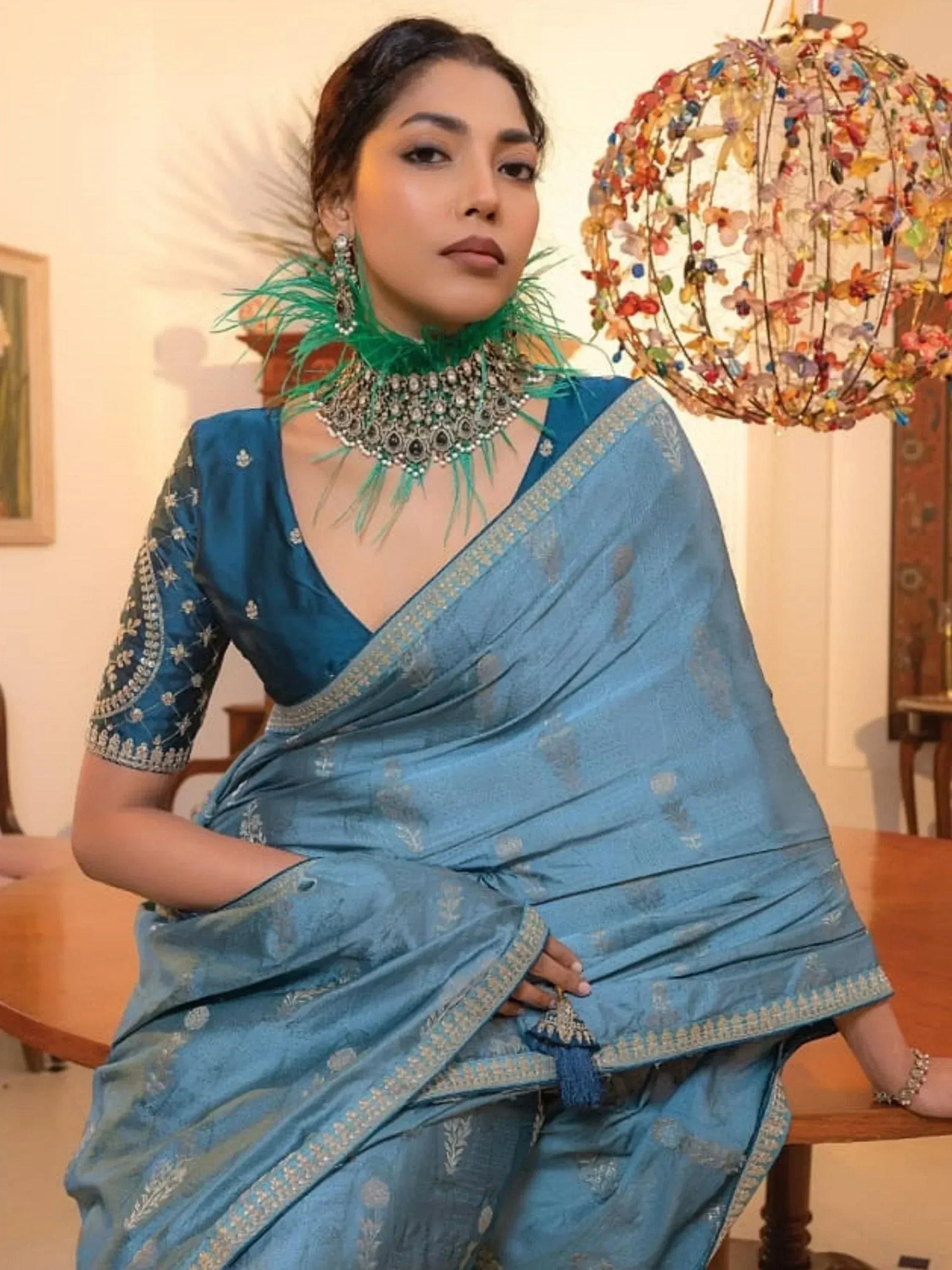 Blue embroidered saree with designer blouse and peacock feather jewelry, perfect for Indian ethnic occasions