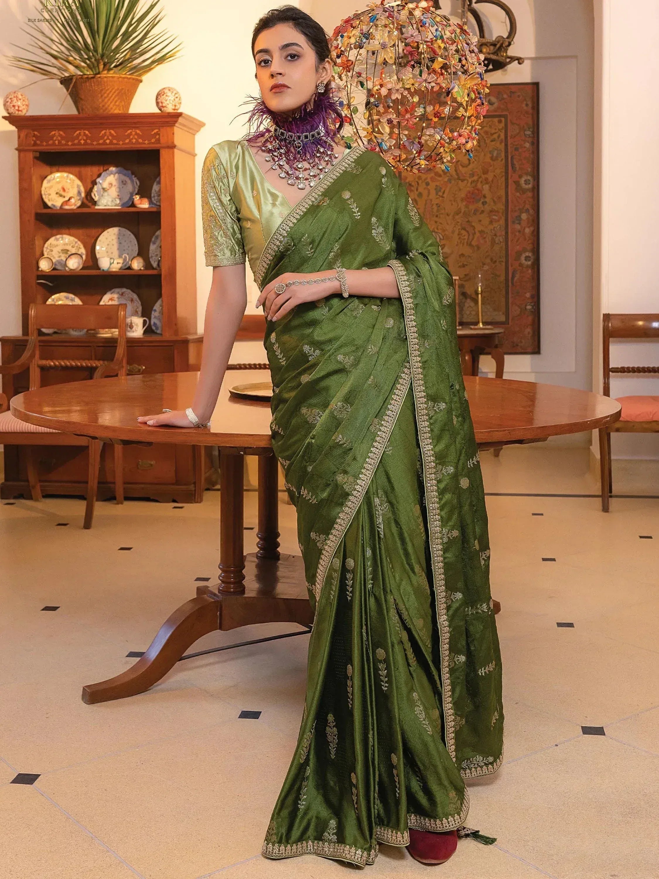 Elegant green embroidered saree with gold border, styled with statement jewelry for Indian ethnic wear