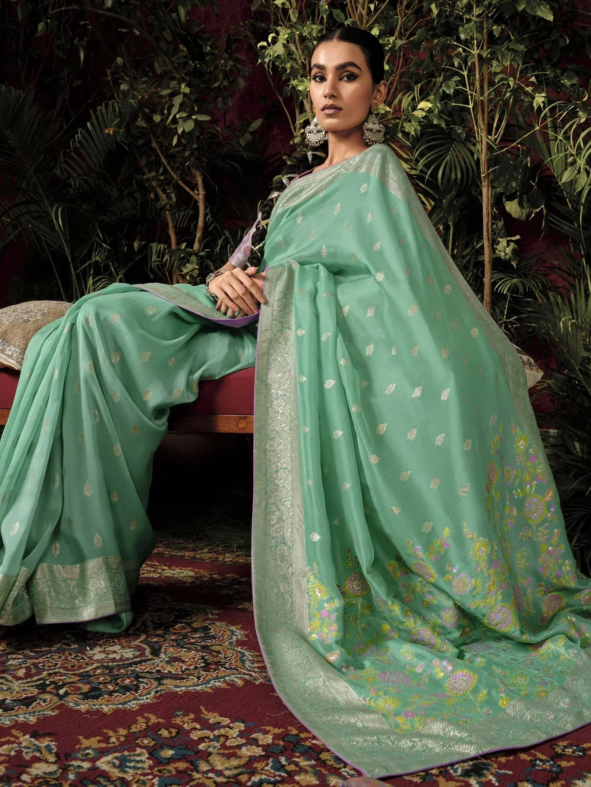 Mint green designer saree with gold floral motifs and silver border, styled with ethnic jewelry for festive occasions.