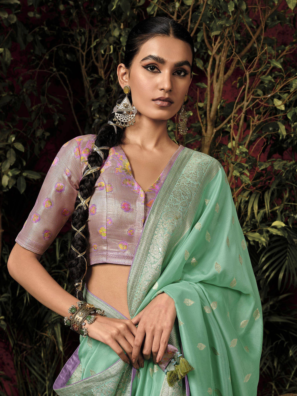 Mint green saree with gold motifs, purple floral blouse, and traditional jewelry for Indian ethnic wear