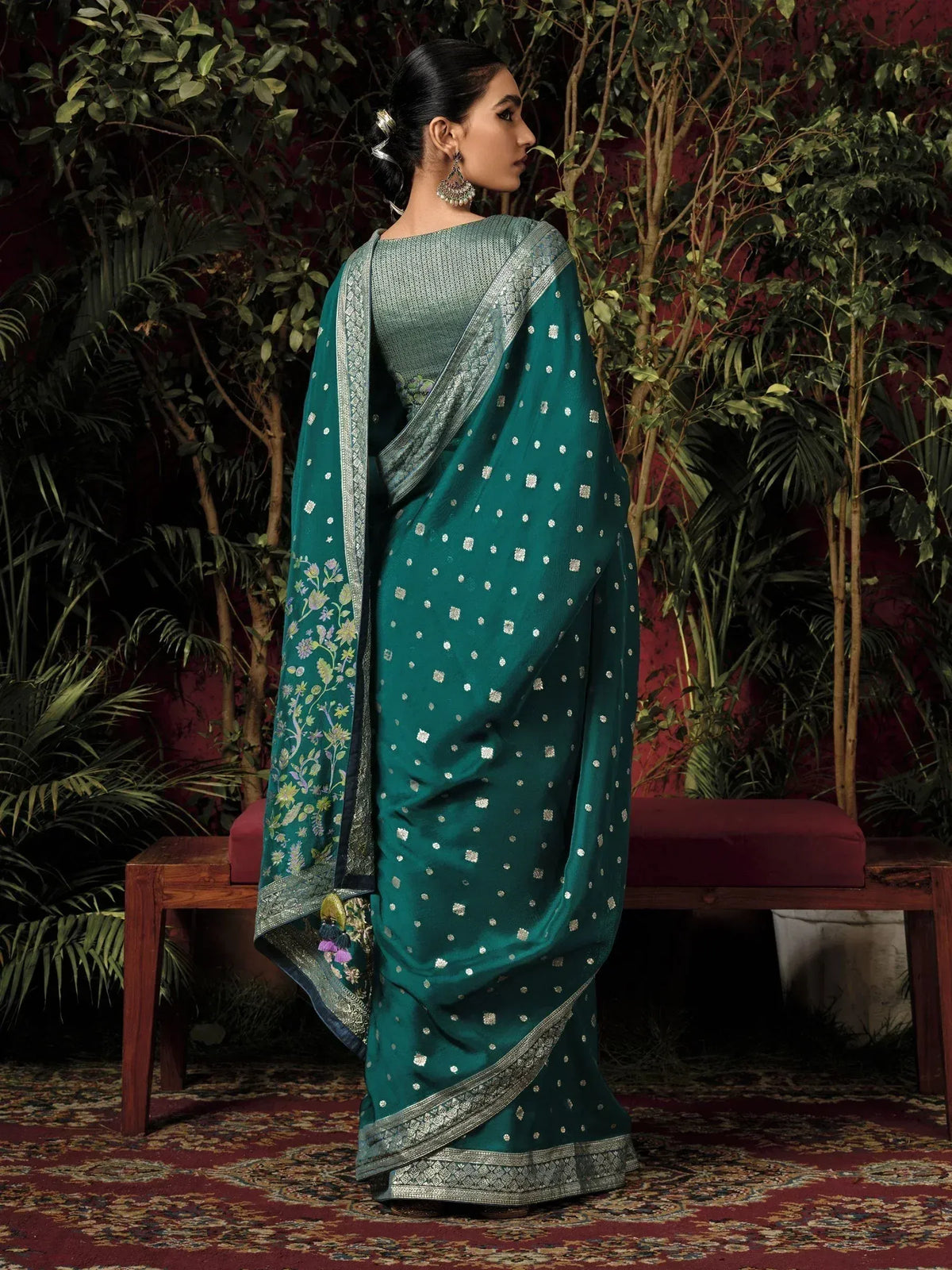 Emerald green designer saree with silver zari work and floral border, perfect for Indian ethnic wear occasions.