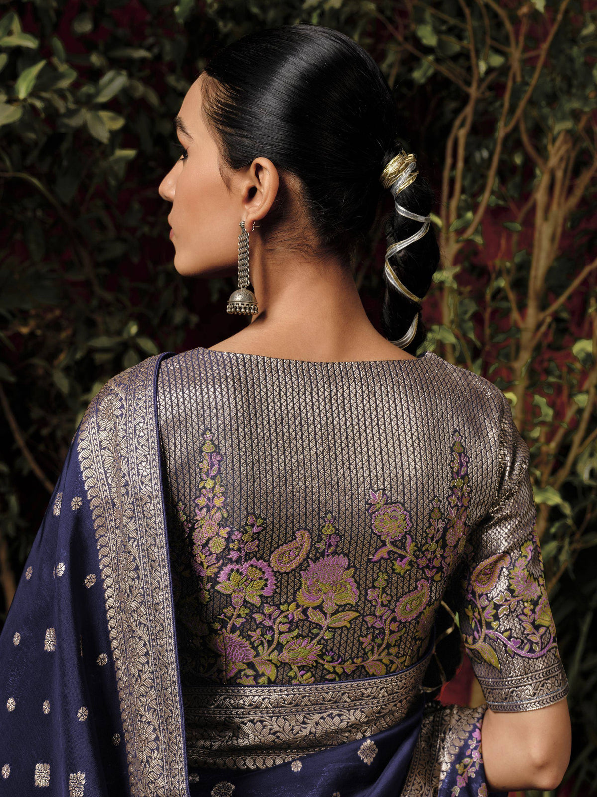 Woman in navy blue and gold embroidered saree with floral back design, traditional Indian ethnic wear