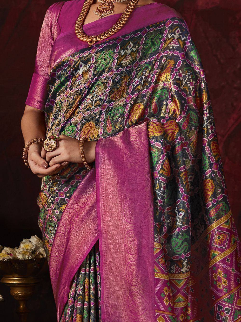 Vibrant purple saree with intricate multicolor geometric print, paired with gold jewelry for ethnic wear