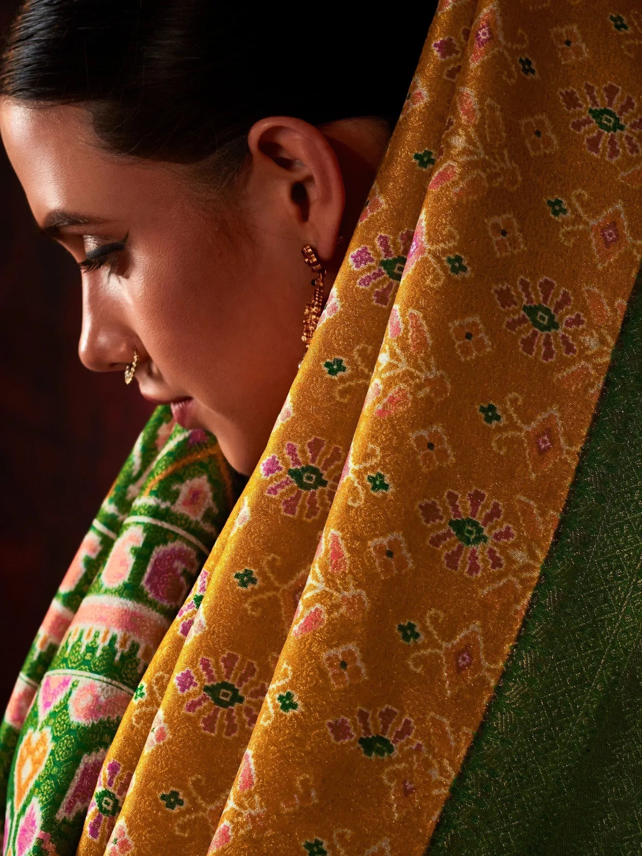 Woman in traditional Indian saree with floral gold and green print, ethnic wear
