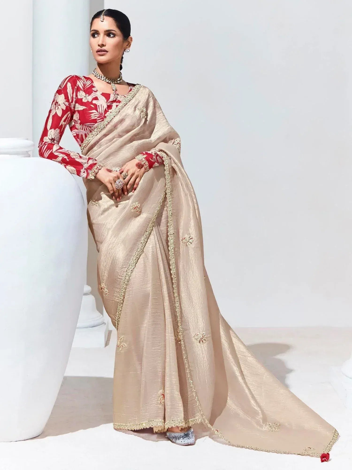 Elegant beige saree with gold embroidery paired with red floral blouse, perfect for Indian ethnic occasions