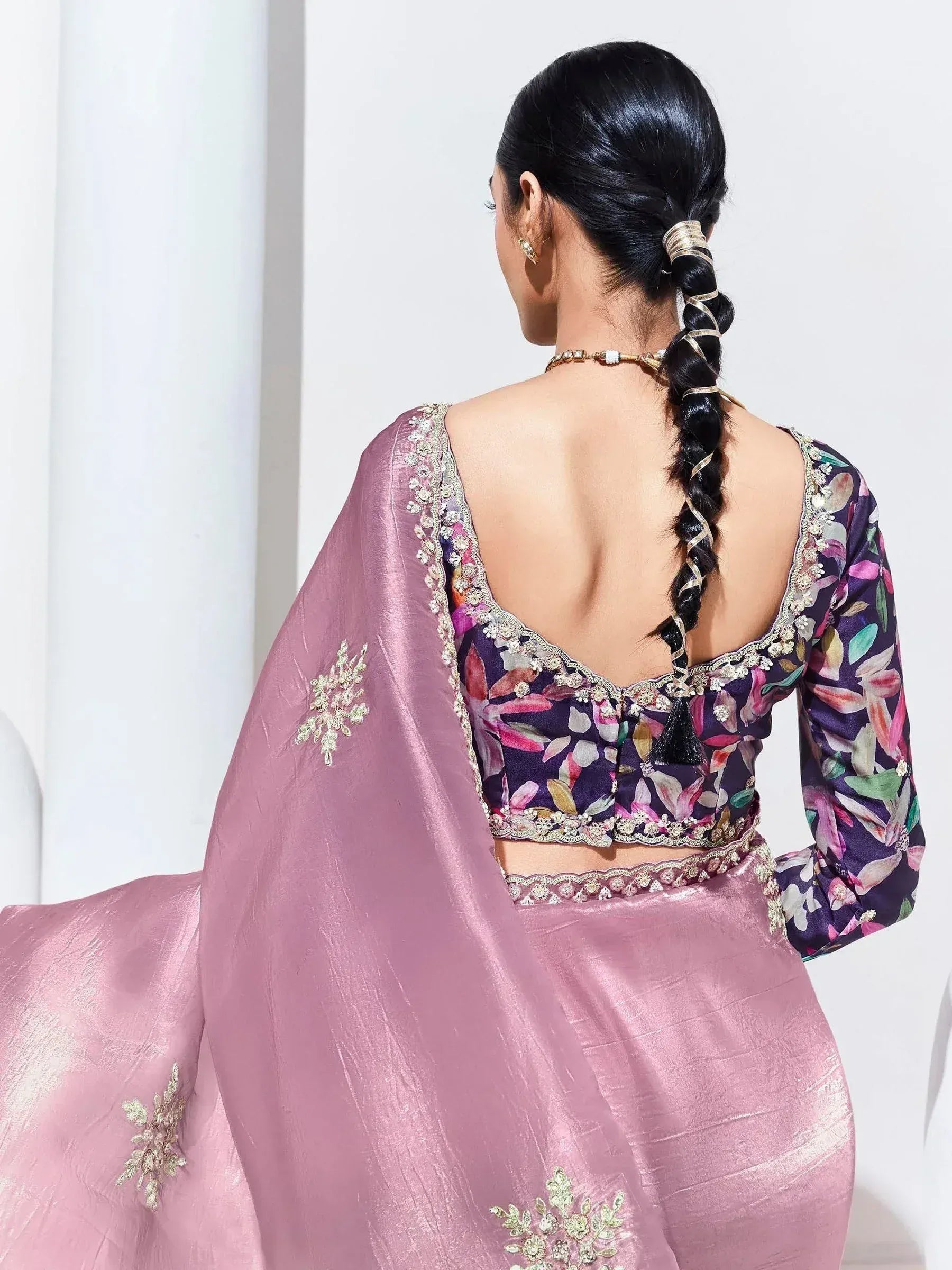 Back view of woman in floral print blouse with open back, paired with pink lehenga and embroidered dupatta, ethnic wear