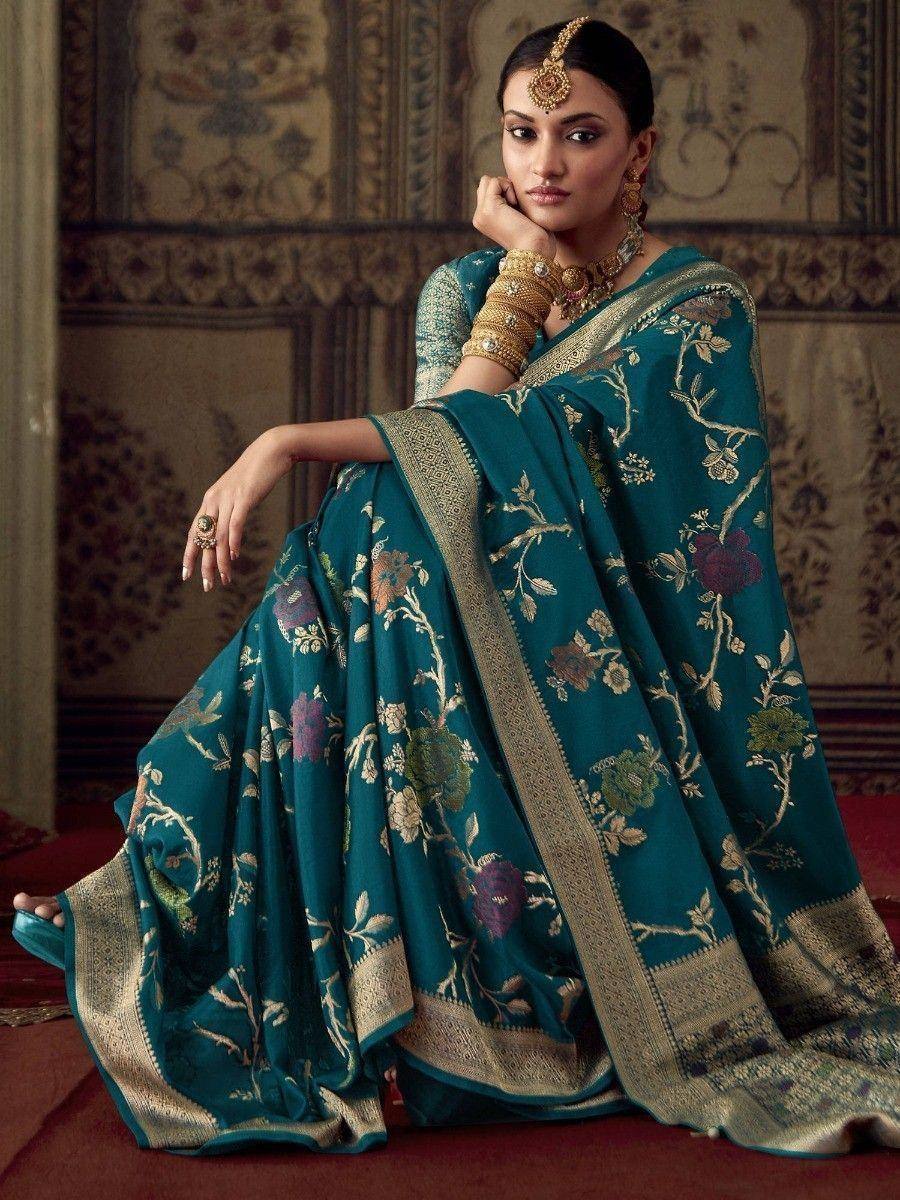 Teal floral embroidered saree with gold border, styled with traditional Indian jewelry for ethnic wear