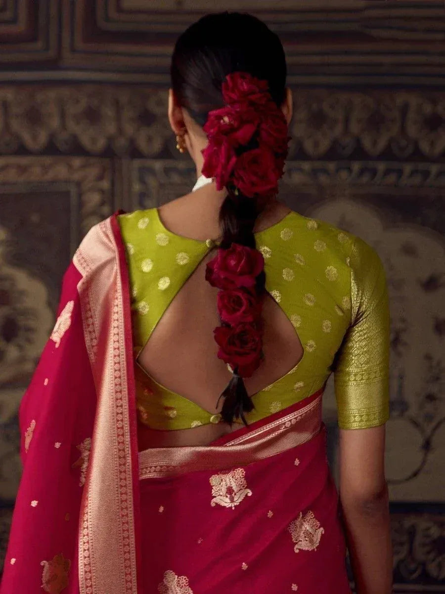 Back view of woman in red saree with gold embroidery and green blouse, hair adorned with red roses
