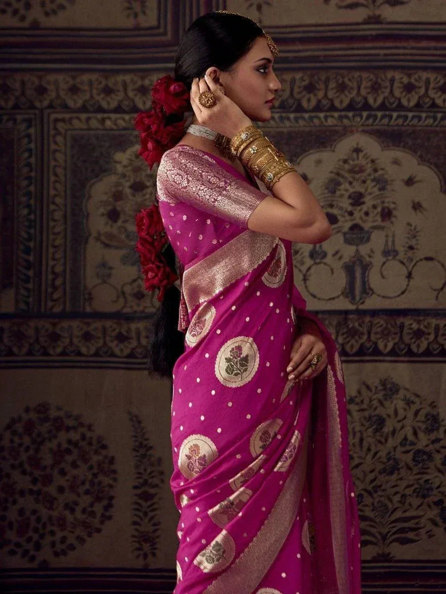 Woman in vibrant pink ethnic saree with gold floral motifs and traditional jewelry, styled for Indian occasions