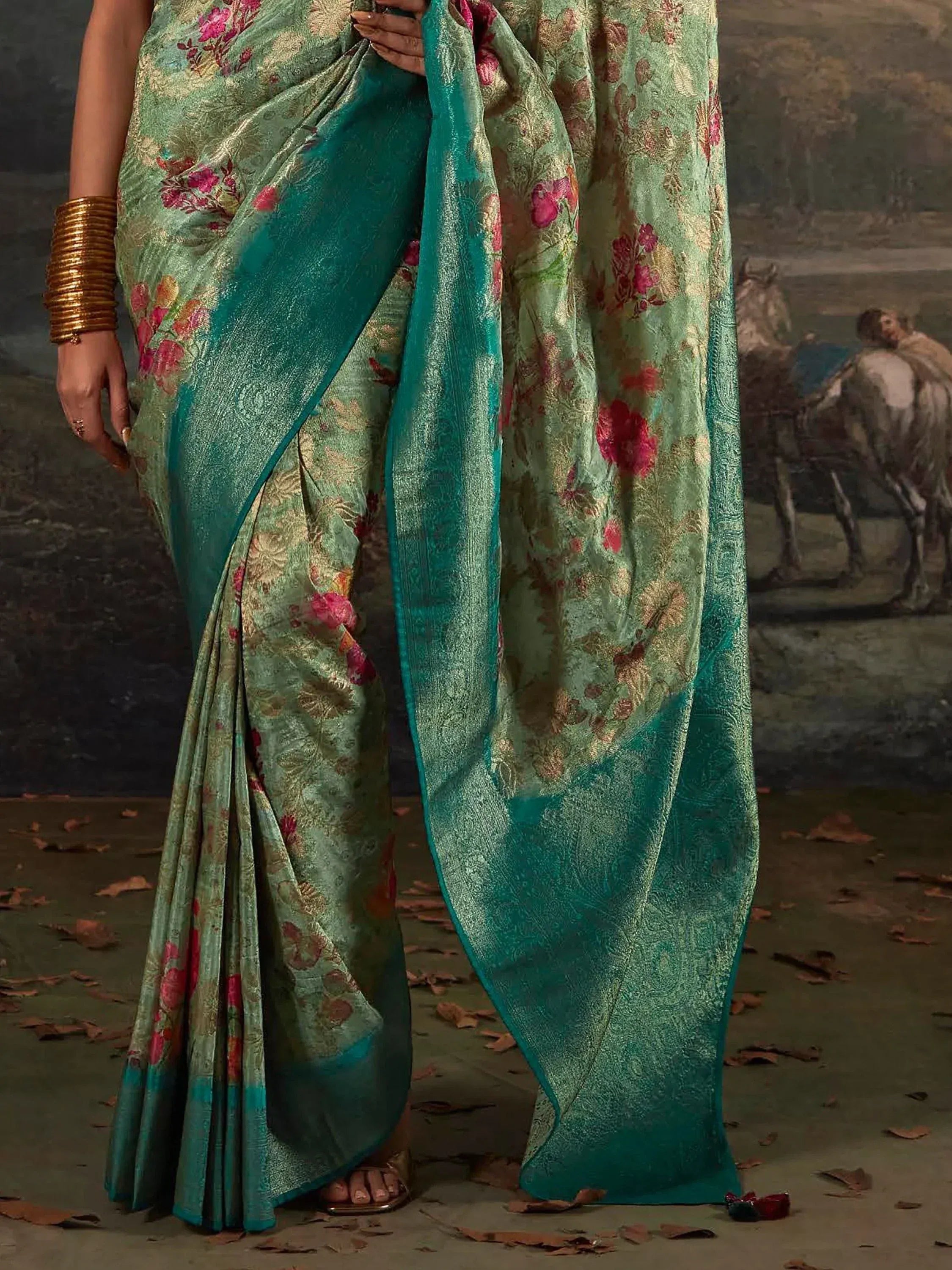 Elegant teal saree with floral embroidery and golden accents, perfect for ethnic occasions.