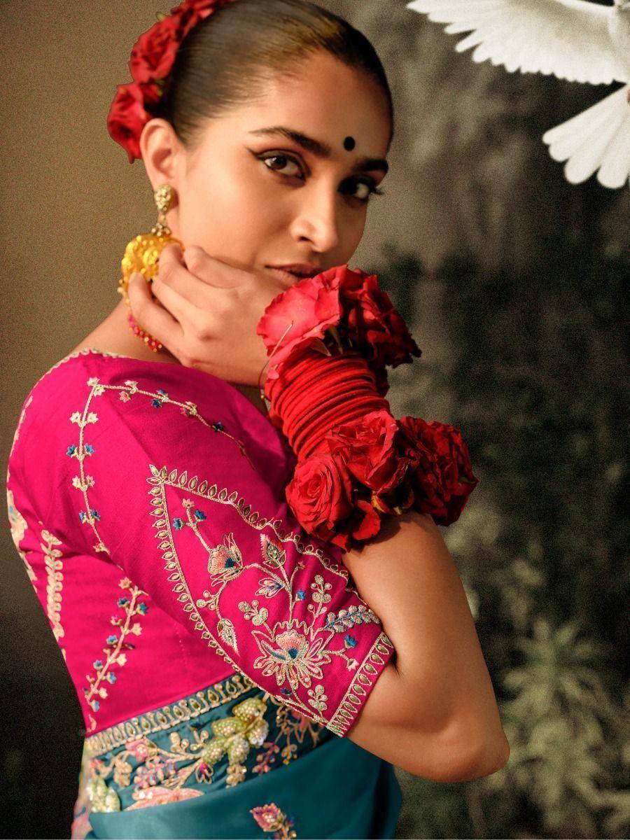 Woman in pink embroidered lehenga choli with red rose accessories, ethnic Indian wear