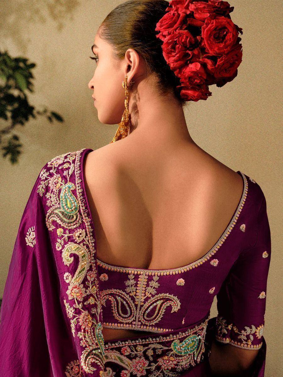 Purple designer lehenga choli with backless blouse, floral embroidery, and red rose hair accessory
