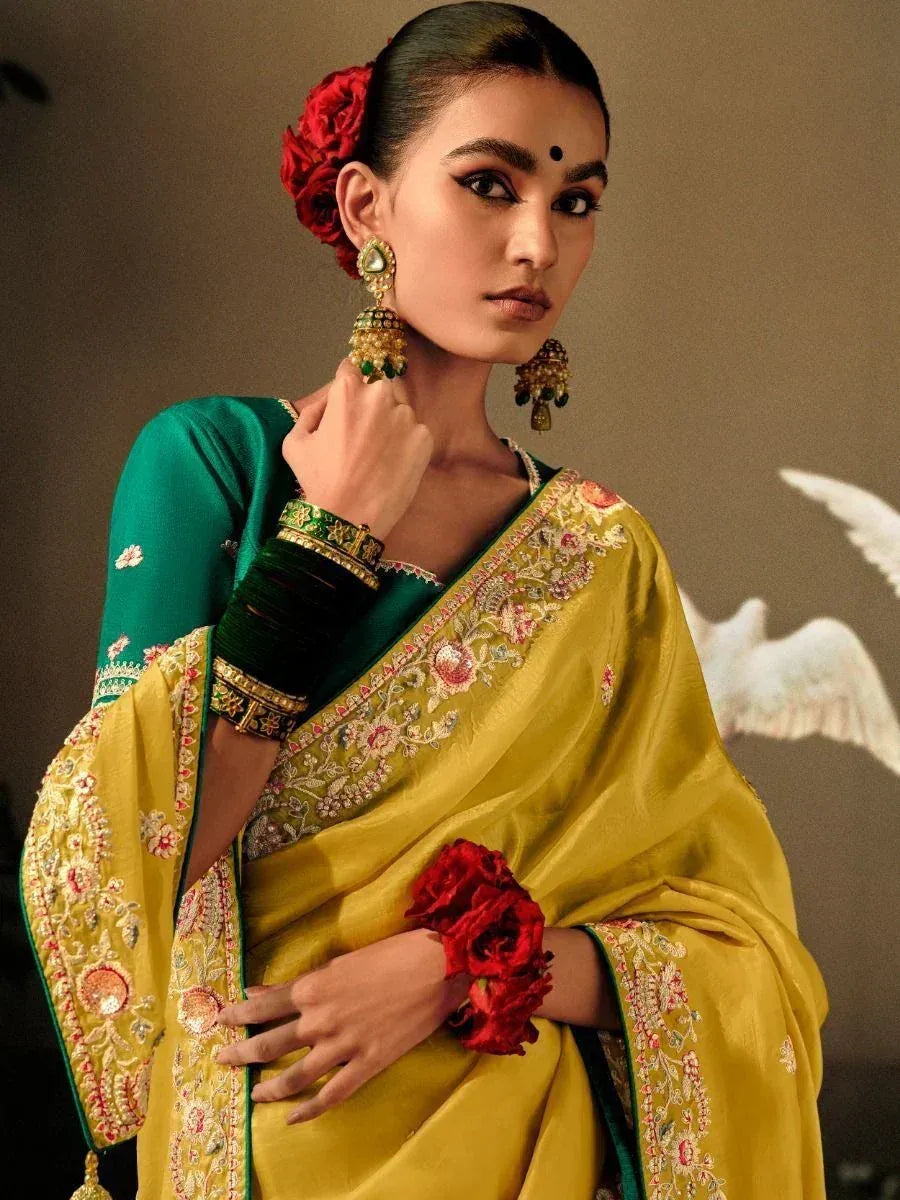 Elegant yellow saree with floral embroidery, green blouse, and traditional jewelry for Indian ethnic wear