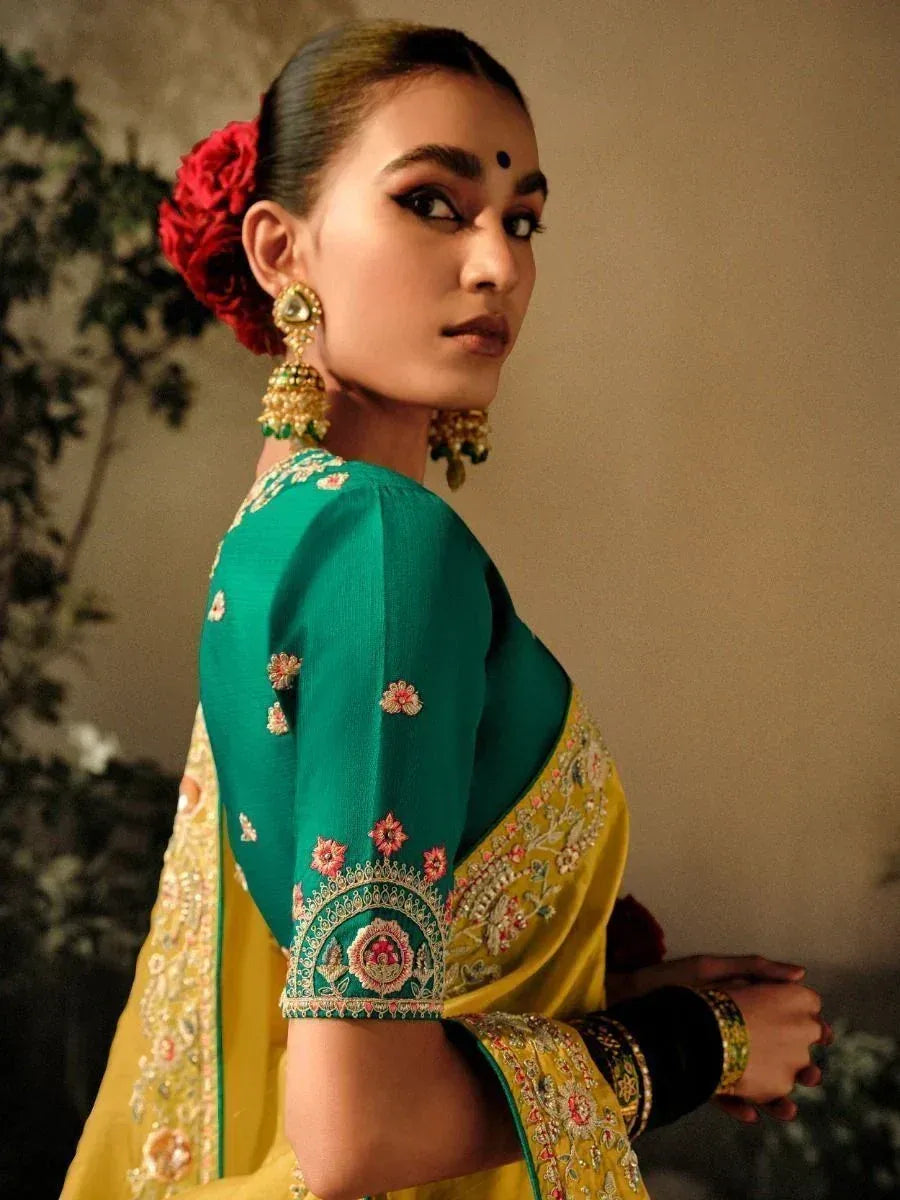 Elegant green and yellow embroidered saree with floral details and traditional jewelry