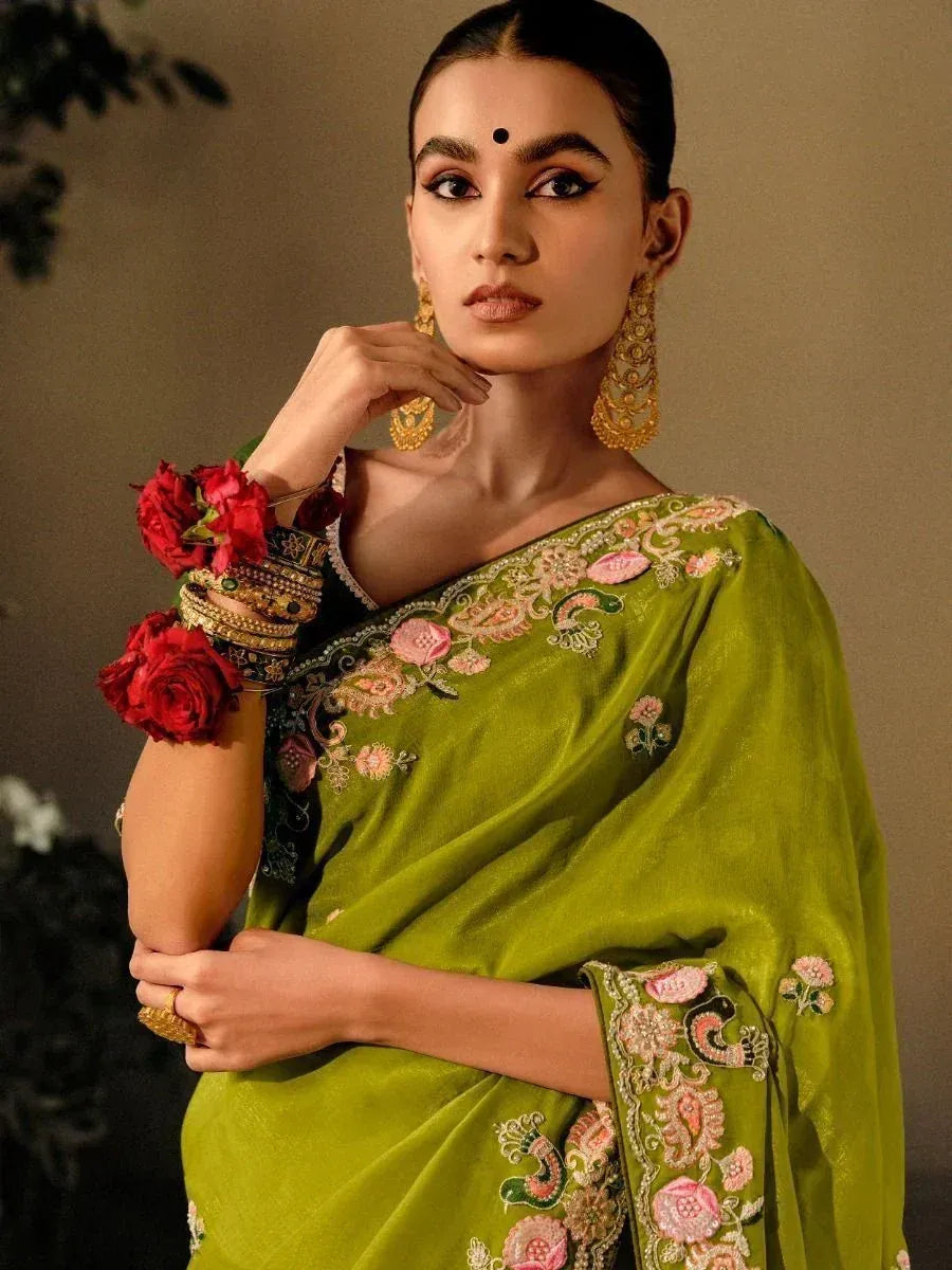 Green embroidered saree with floral design, gold jewelry, and red rose bangles for Indian ethnic wear