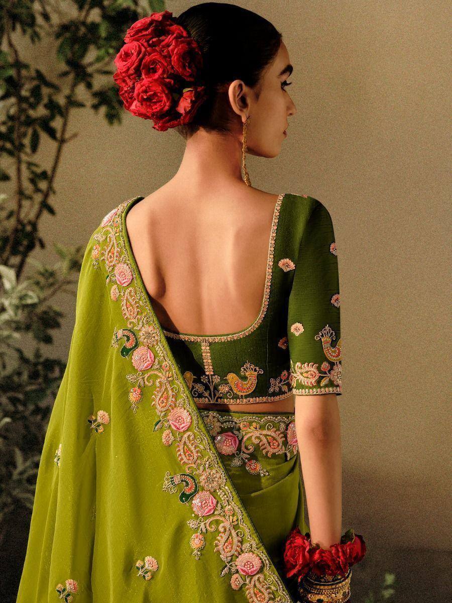 Green embroidered saree with floral peacock motifs, backless blouse, red rose hair accessory