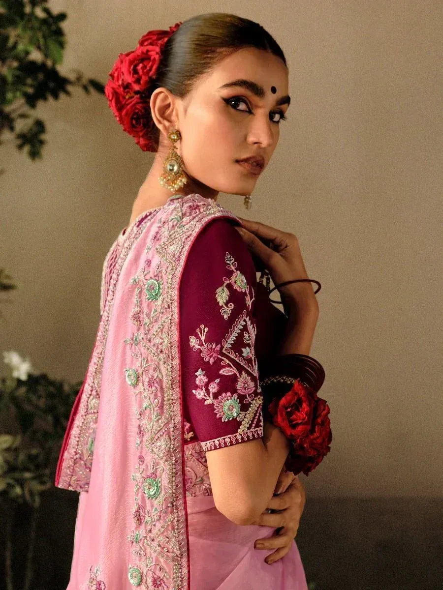 Pink embroidered saree with maroon blouse, floral hair accessory, and traditional jewelry for Indian ethnic wear